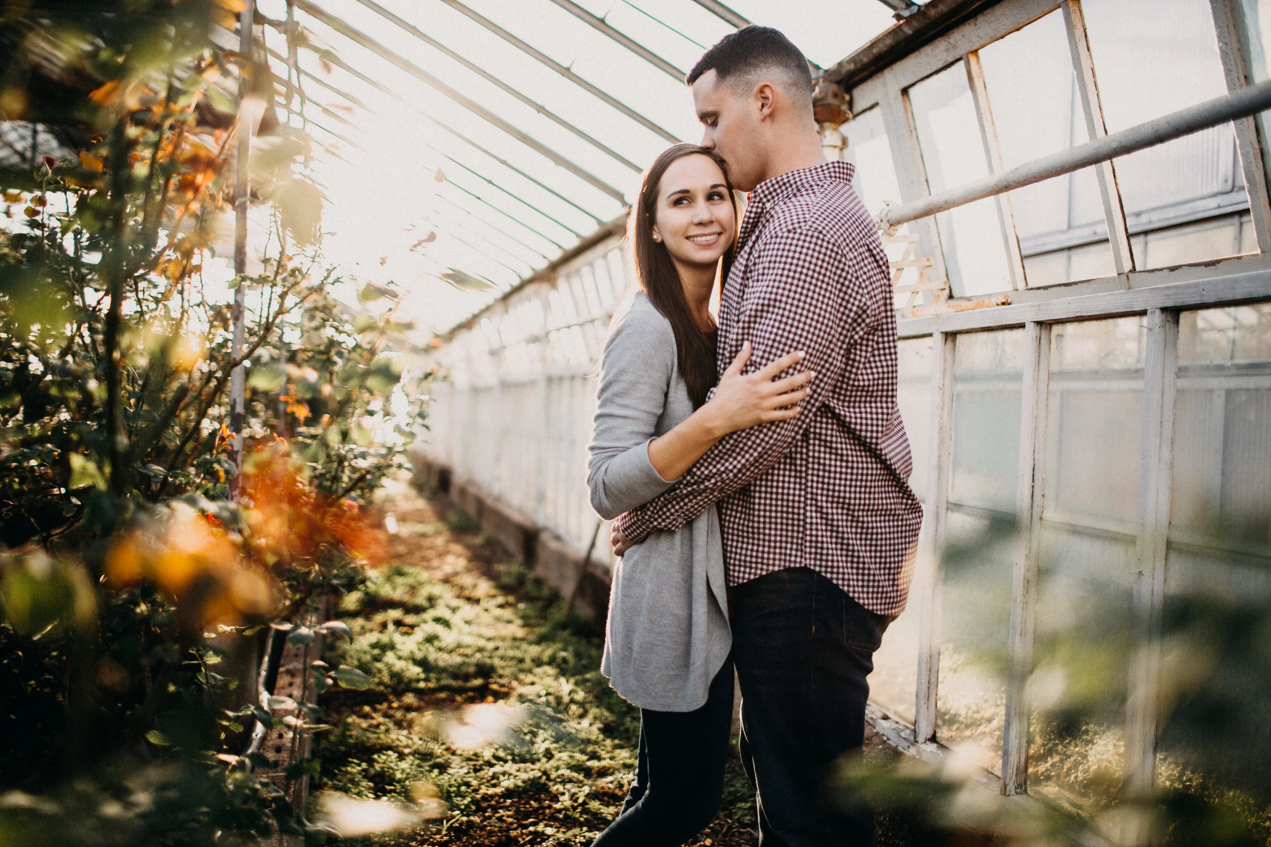 Couple embracing in green house.