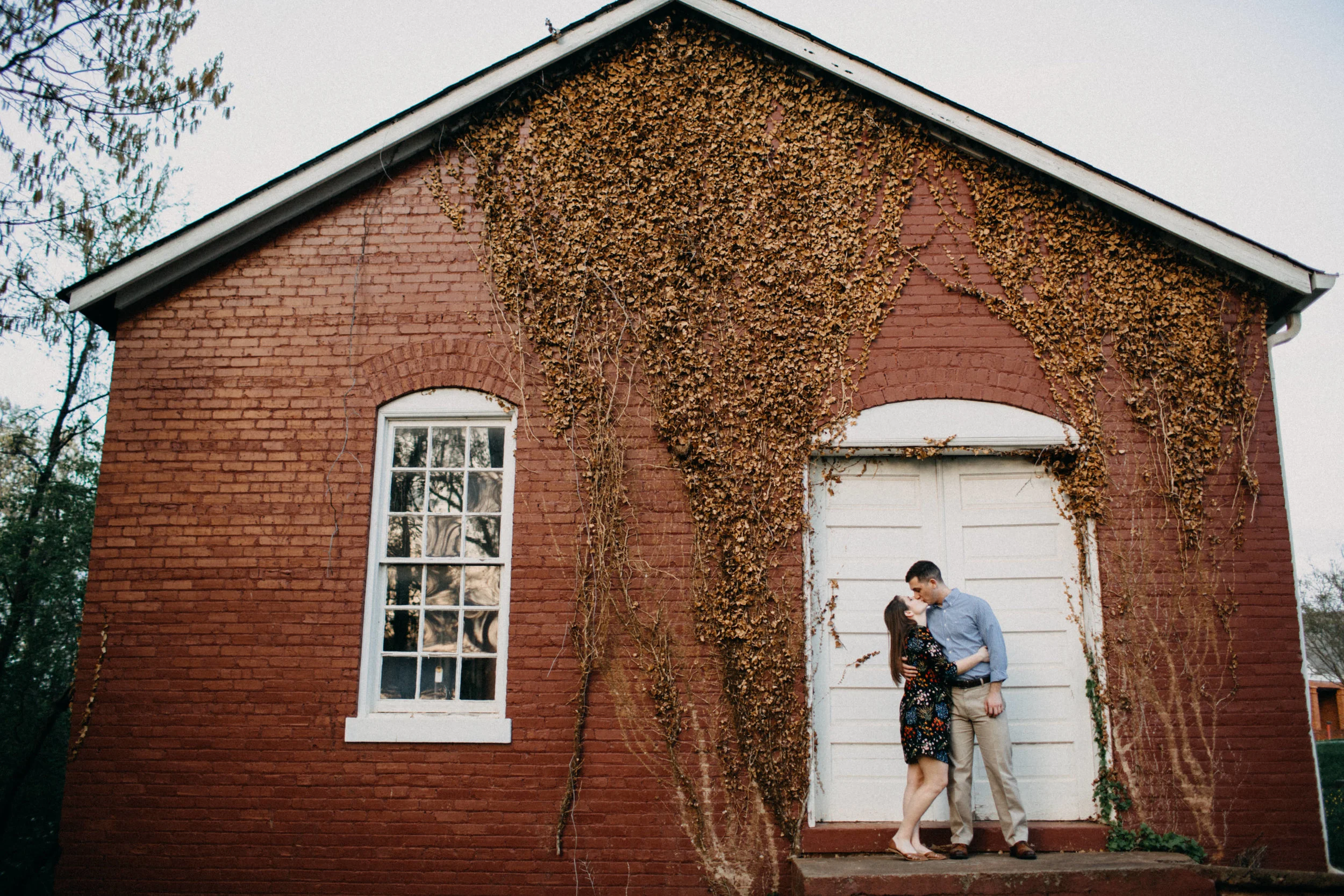 Couple embracing in front of building.
