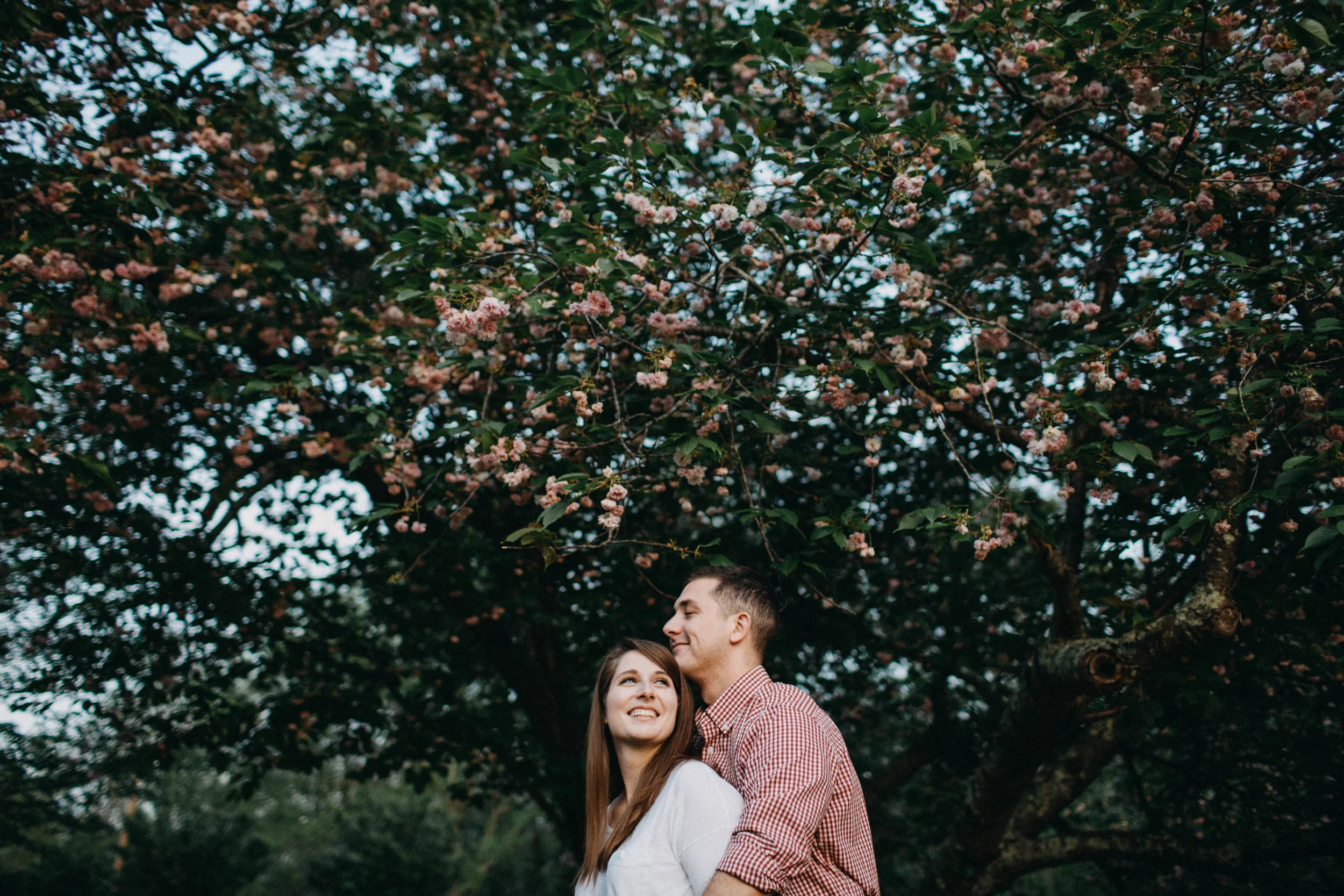 Couple standing beneath trees.