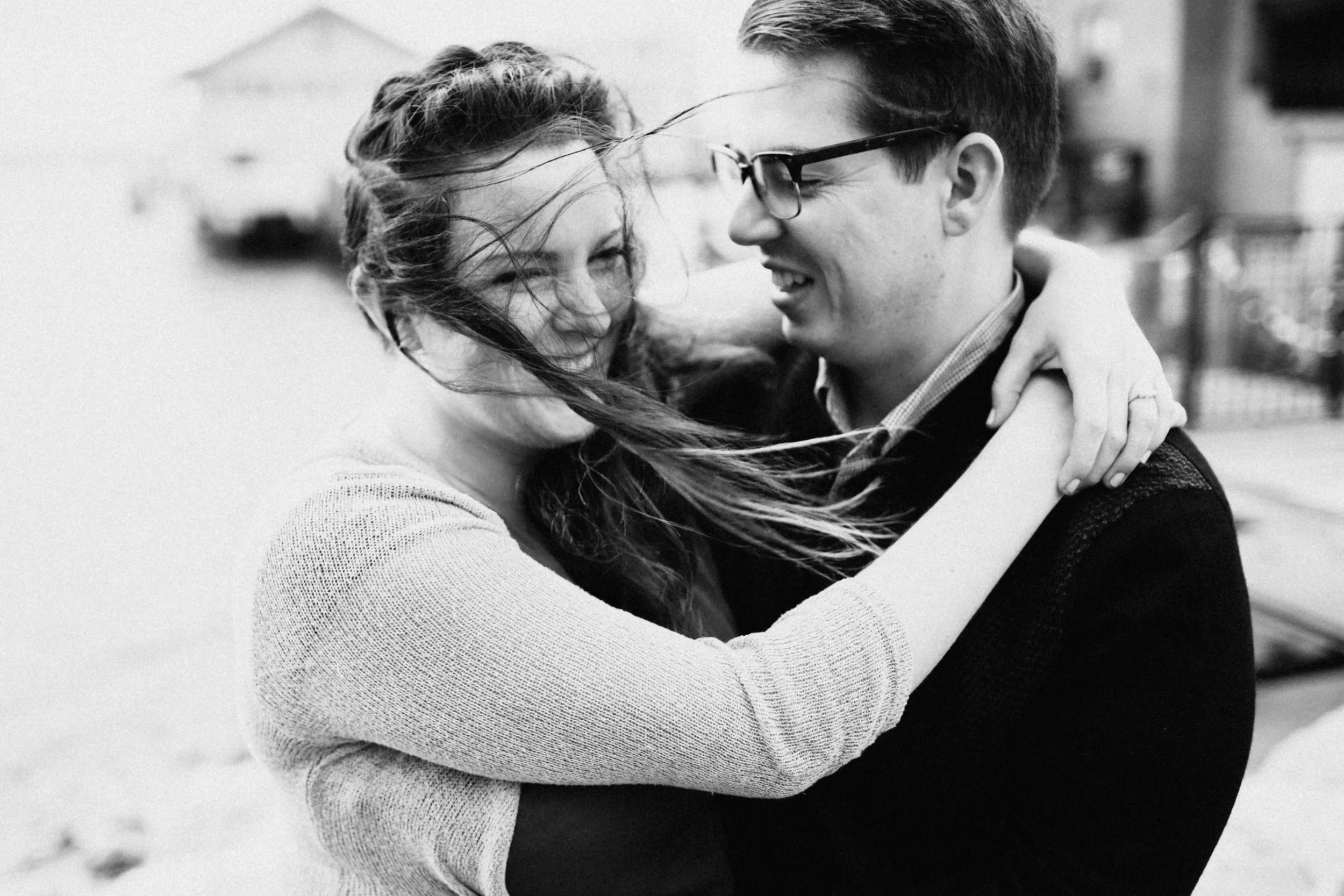 Couple embracing beside marina.