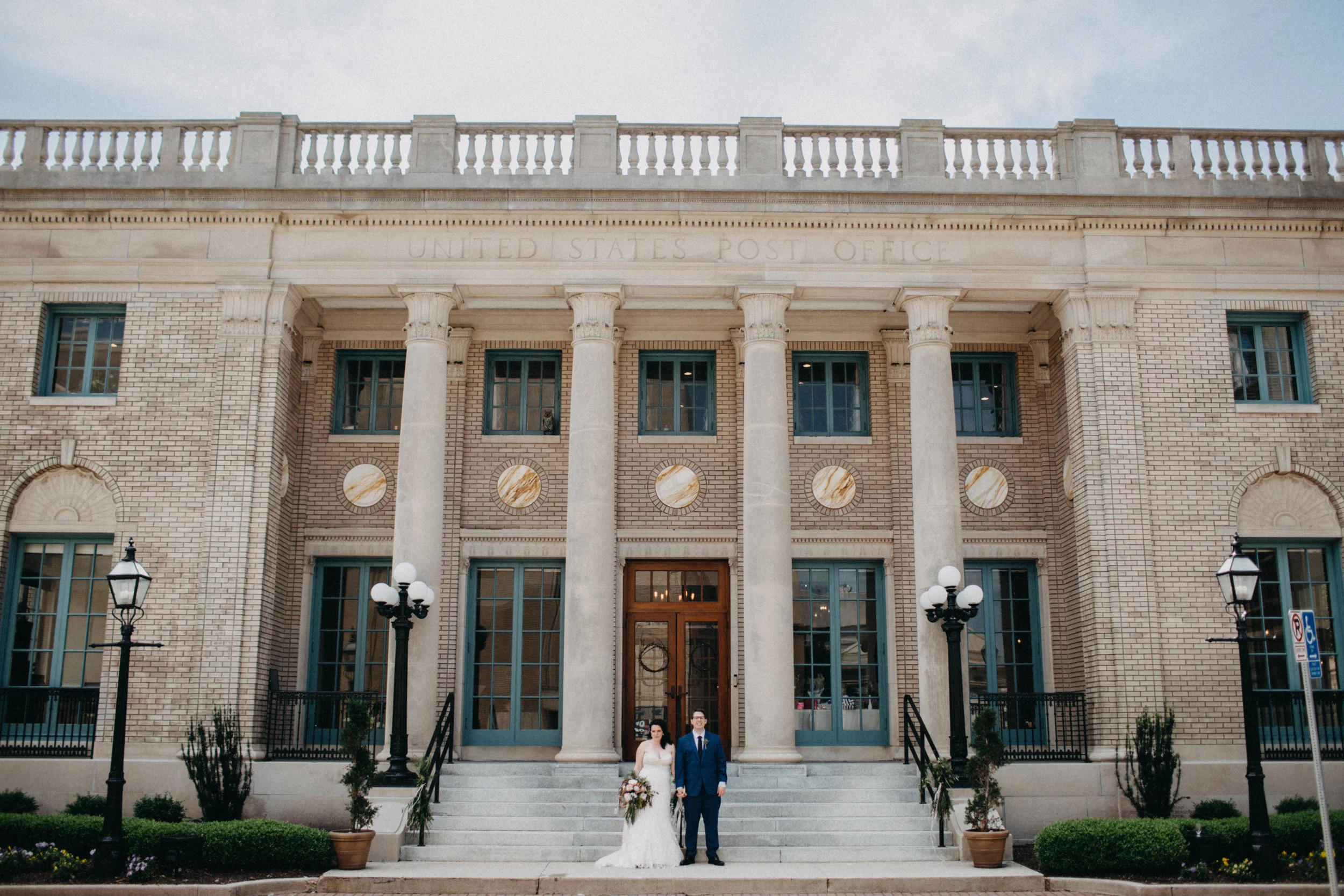 Portrait of couple standing in front of The Historic Post Office, in VA.