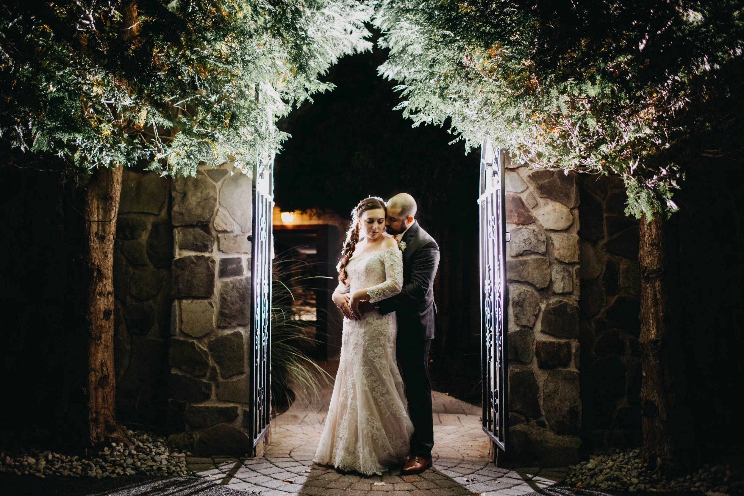 Portrait of couple standing together beneath archway, at the Stroudsmoore Country Inn, PA.