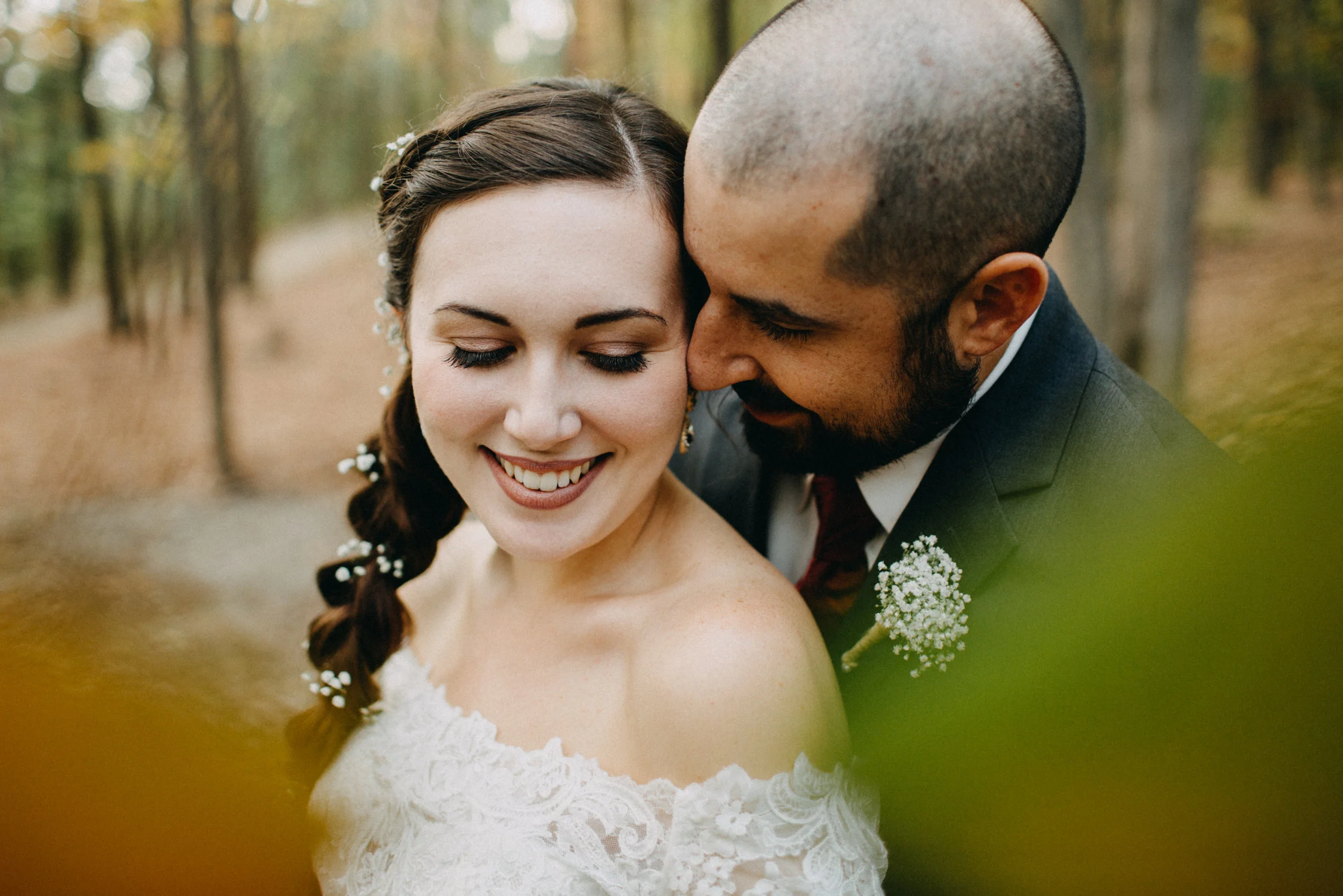 Portrait of couple standing together in woods.