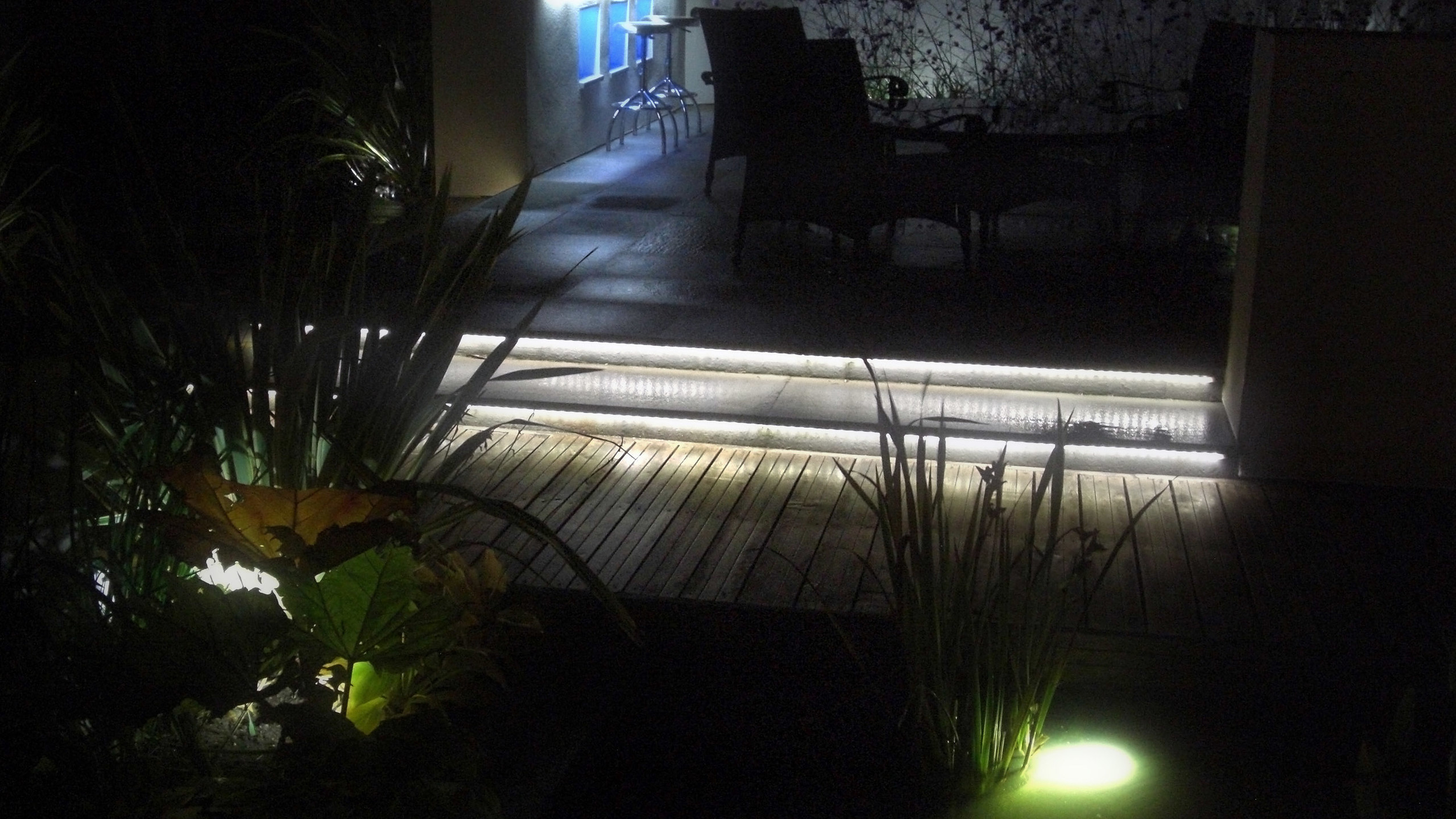 Contemporary garden by night with bar and dining area