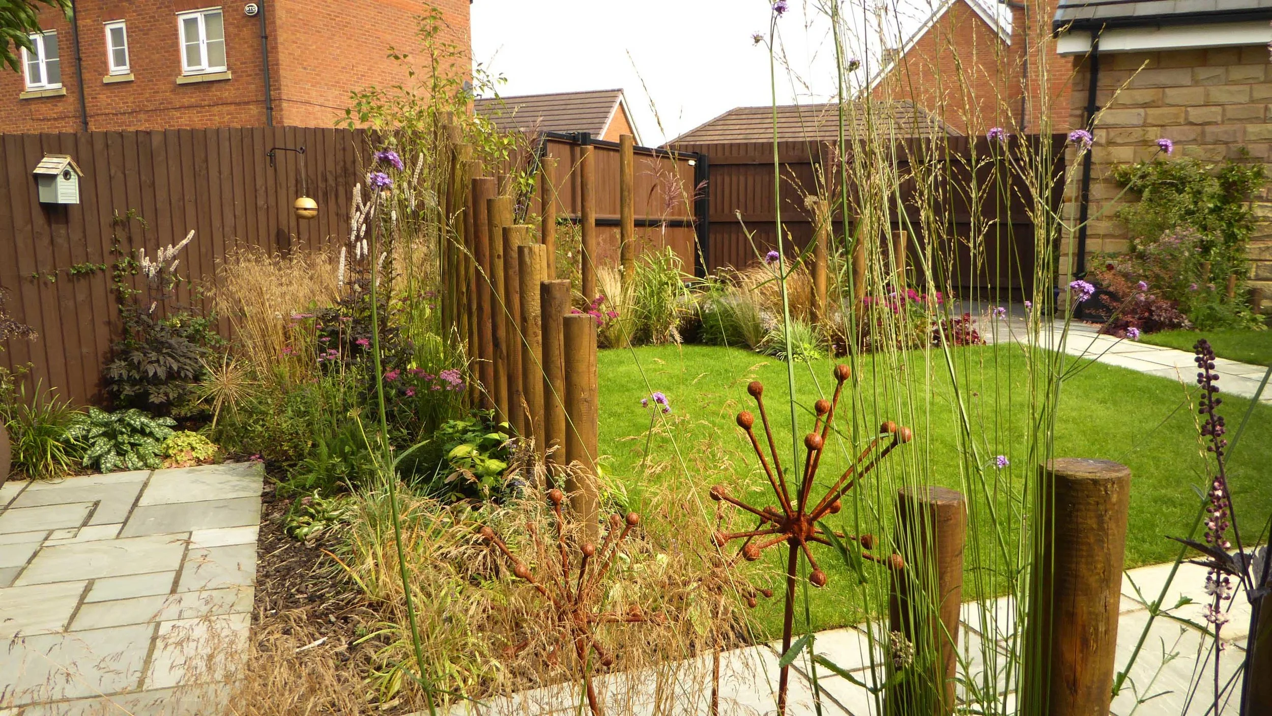 AFTER - New planting beds and feature posts help screen the garden and patio.
