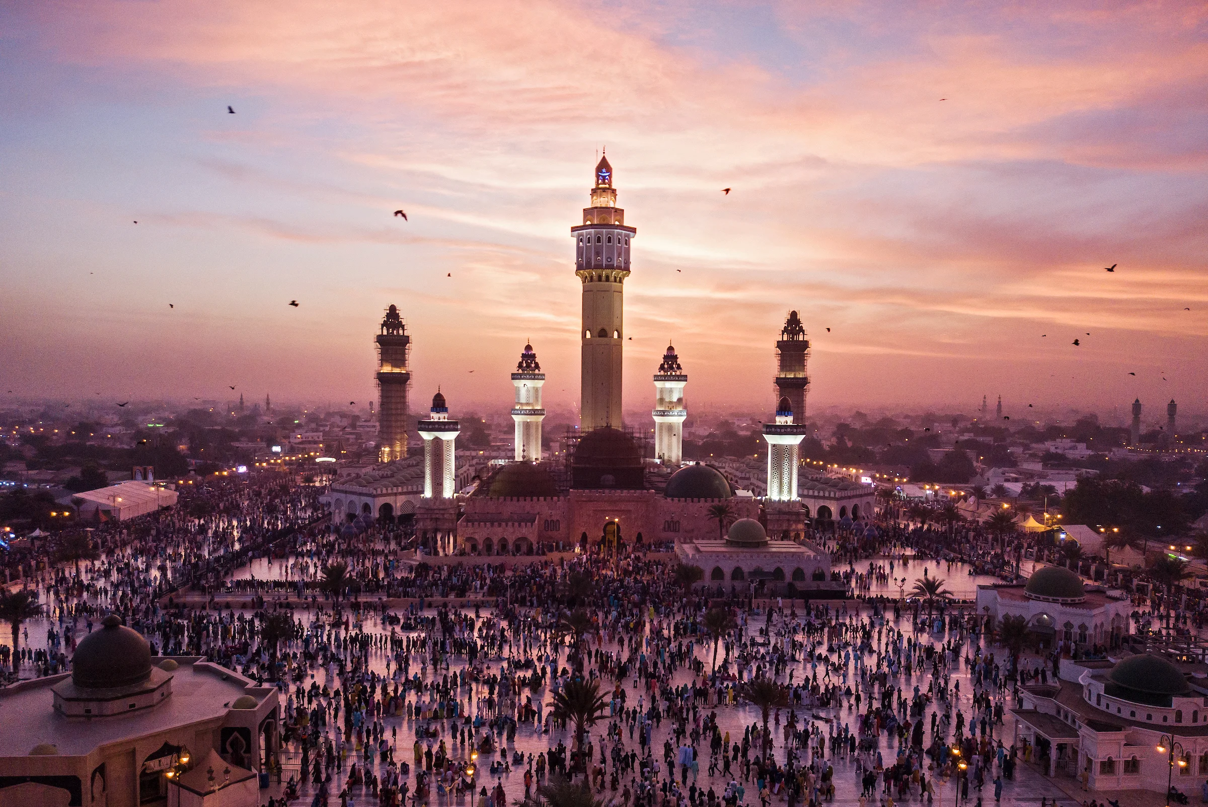8. November 2017. Fledermäuse schwärmen aus, während sich am Abend des Grand Magal Festes in der Großen Moschee in der heiligen Stadt Touba Tausende von Gläubigen zum Abendgebet versammeln. Die Moschee, in der der Körper von Amadou Bamba begraben ist, wurde am 7. Juni 1963 eingeweiht.