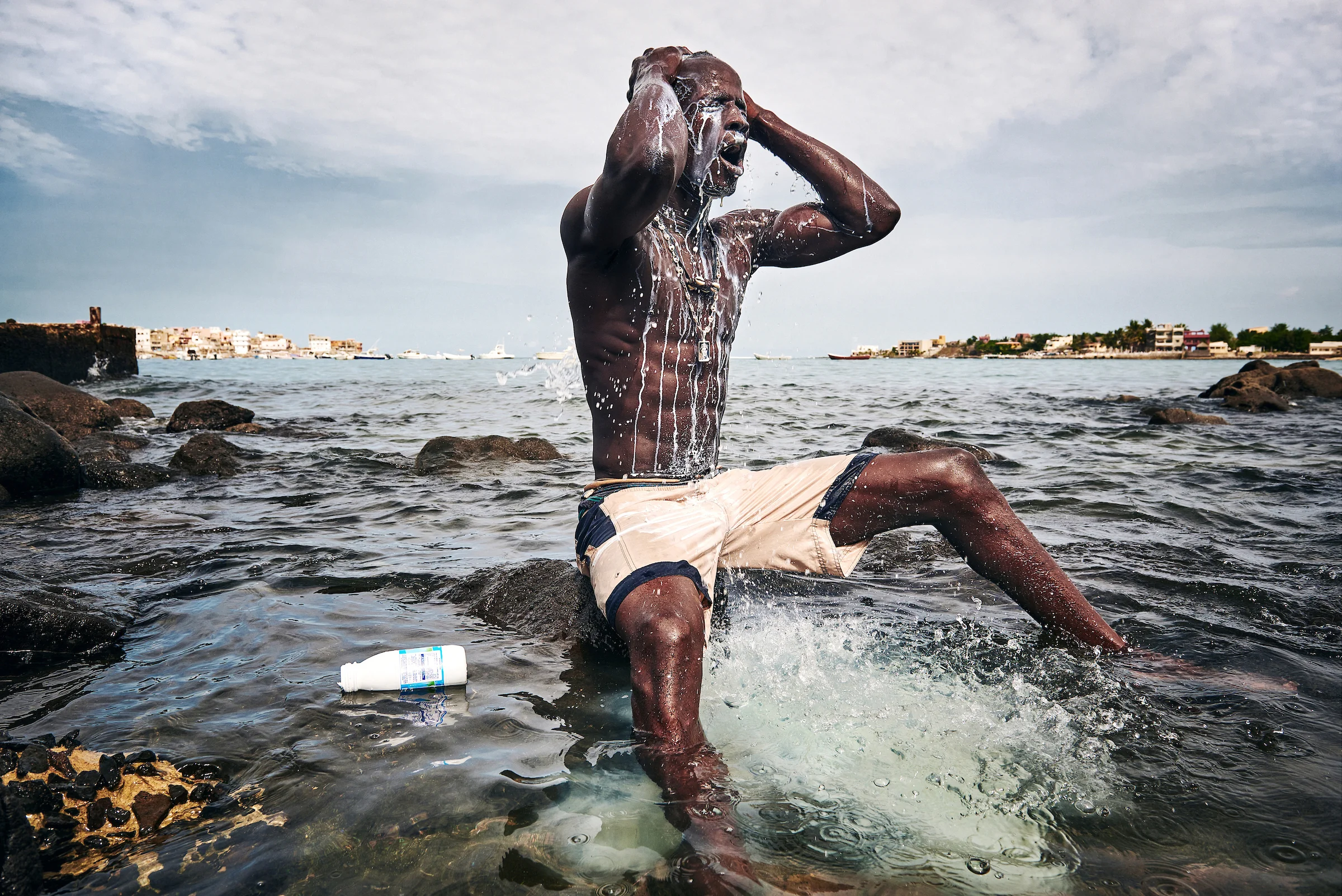 11. August 2015. Kherou Ngor übergiesst seinen Körper im Wasser am Strand von Ngor mit Kuhmilch. Er führt dieses Ritual durch, um sich mit der Kraft eines mächtigen Geistes zu verbinden, der angeblich im Wasser und den Felsen am Ufer des Strands von Ngor lebt.