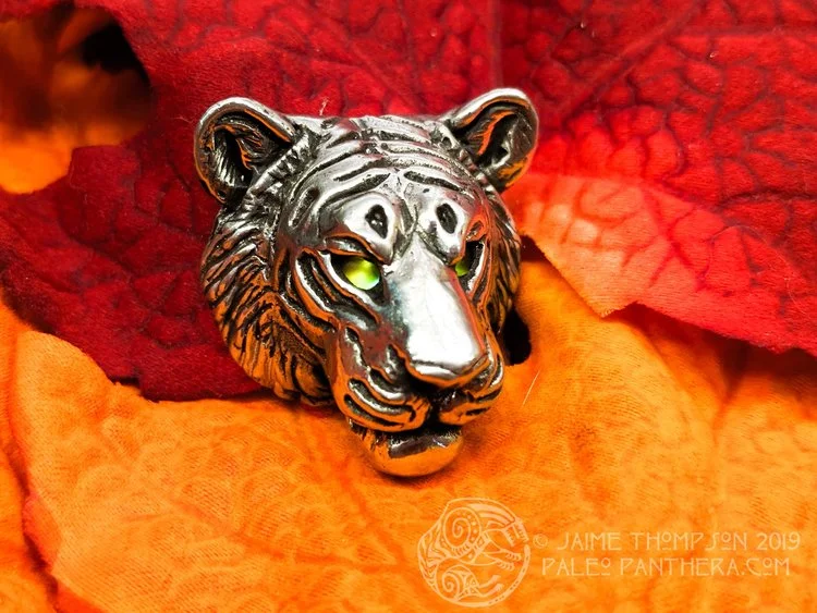 Pewter tiger with green-gold vintage glass eyes.