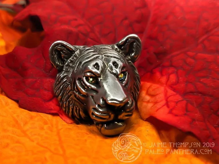 Oxidized tiger pendant with vintage orange metallic eyes.