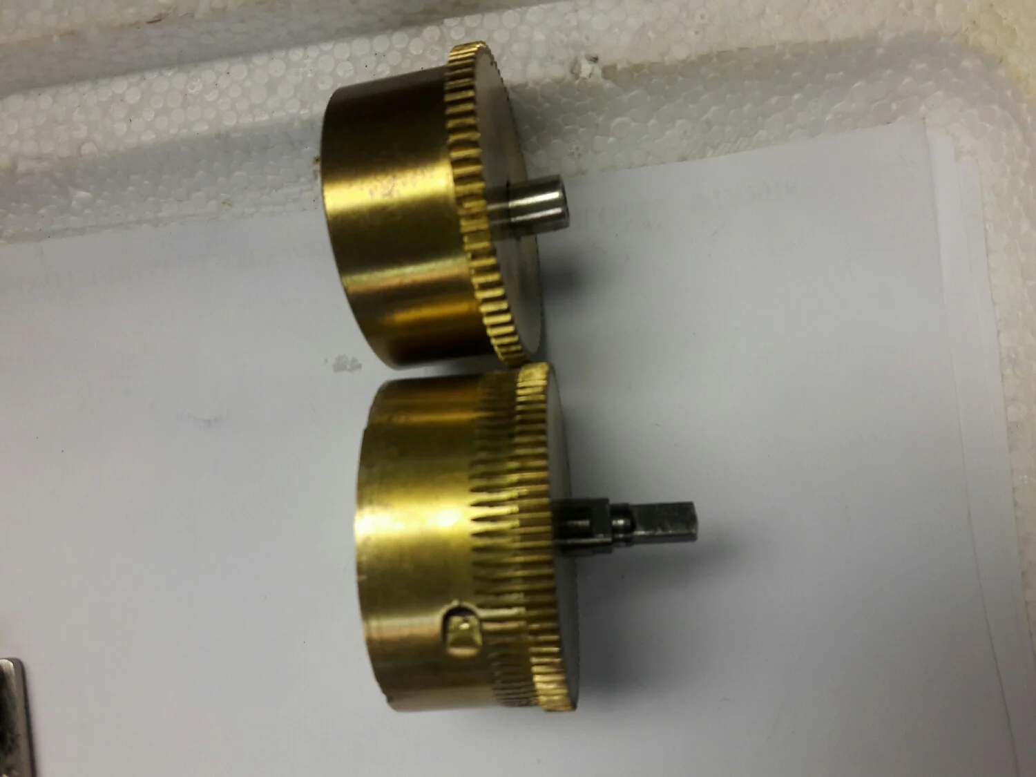The top mainspring barrel is the right way to cut the teeth . On the bottom one they put the blank wheel on the brass tube with solder . Then they cut the the desired number of teeth . The result is teeth cut into the barrel it's self . You never know what you will come across in clock repair .
