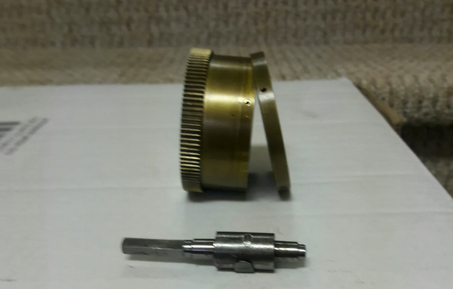 most mainspring barrels have a snap on lid that is flush with the non gear end of the barrel. Here we see a cap that is snapped onto the barrel and secured with 4 tiny screws . 