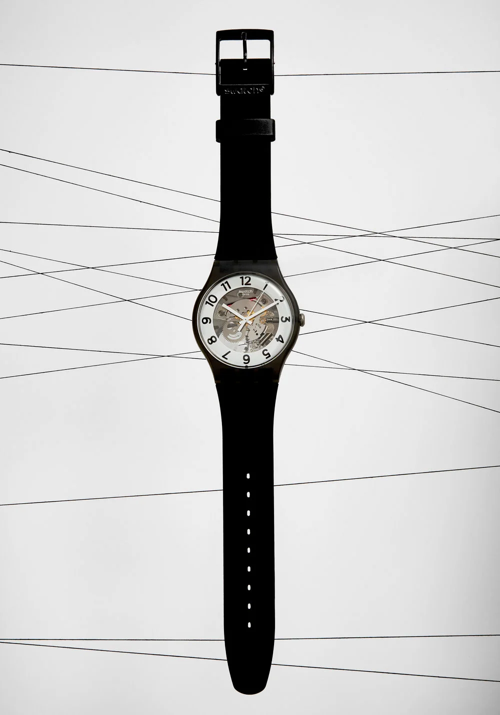  Black Swatch Watch floating on black thread lines. Still Life Photograph by London Based Still Life Photographer Andy Carson 