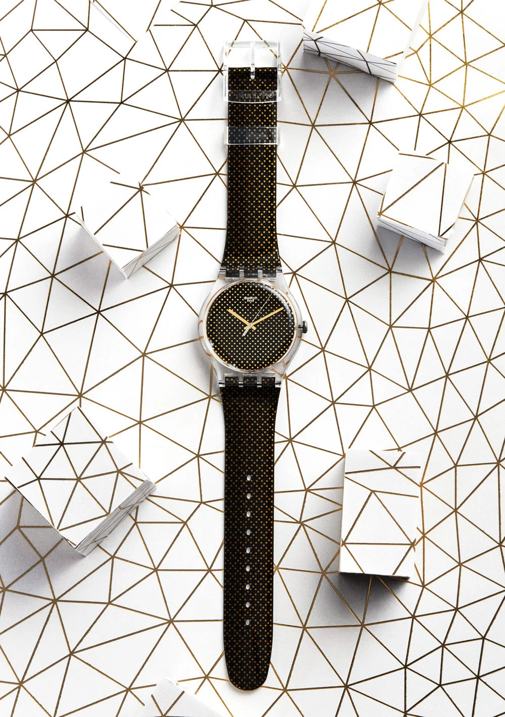  Gold and black Swatch Watch resting on gold lined white background with blocks either side. Still Life Photograph by London Based Still Life Photographer Andy Carson 