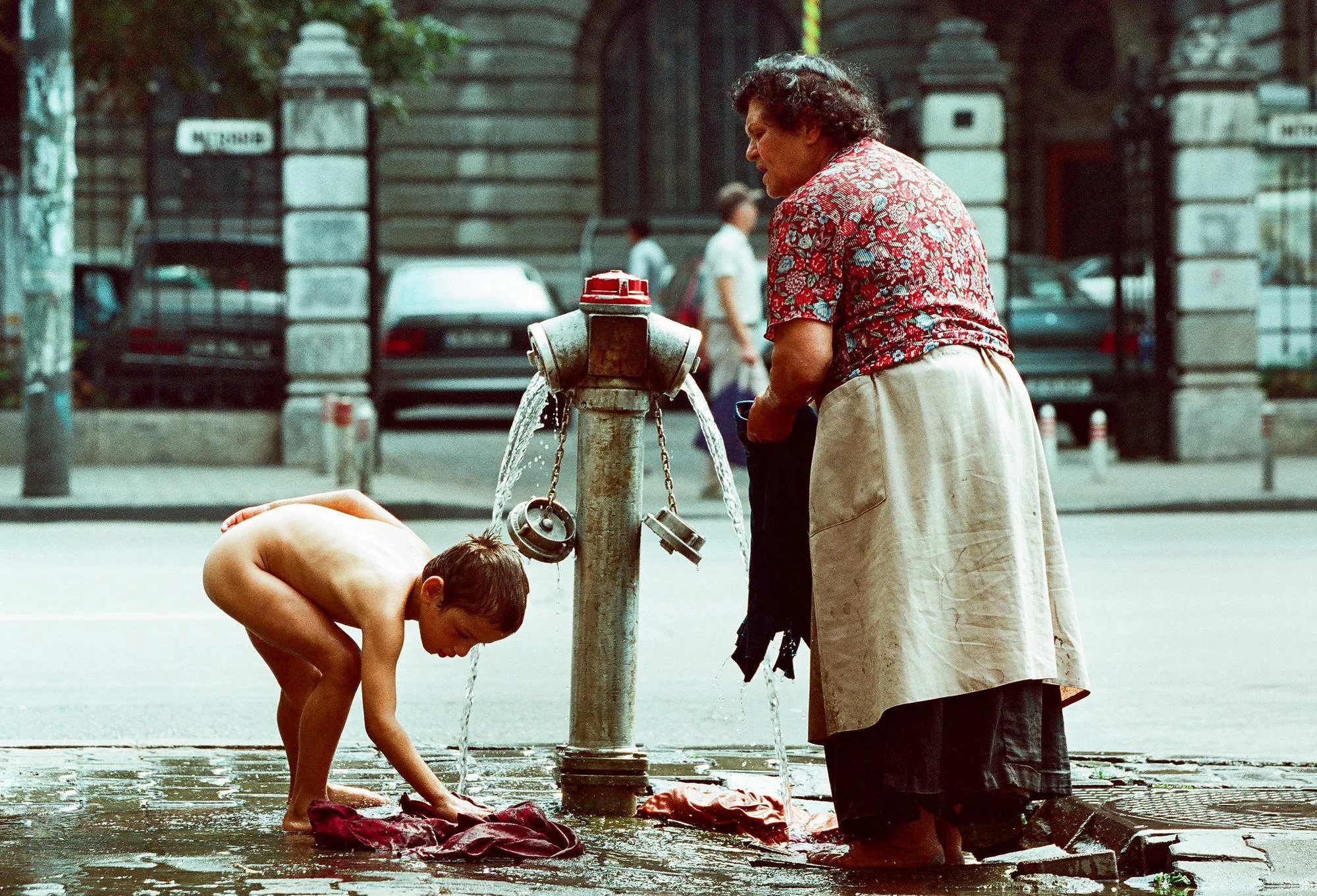 A child washes at a fire hydrant in downtown Bucharest, june 1999.