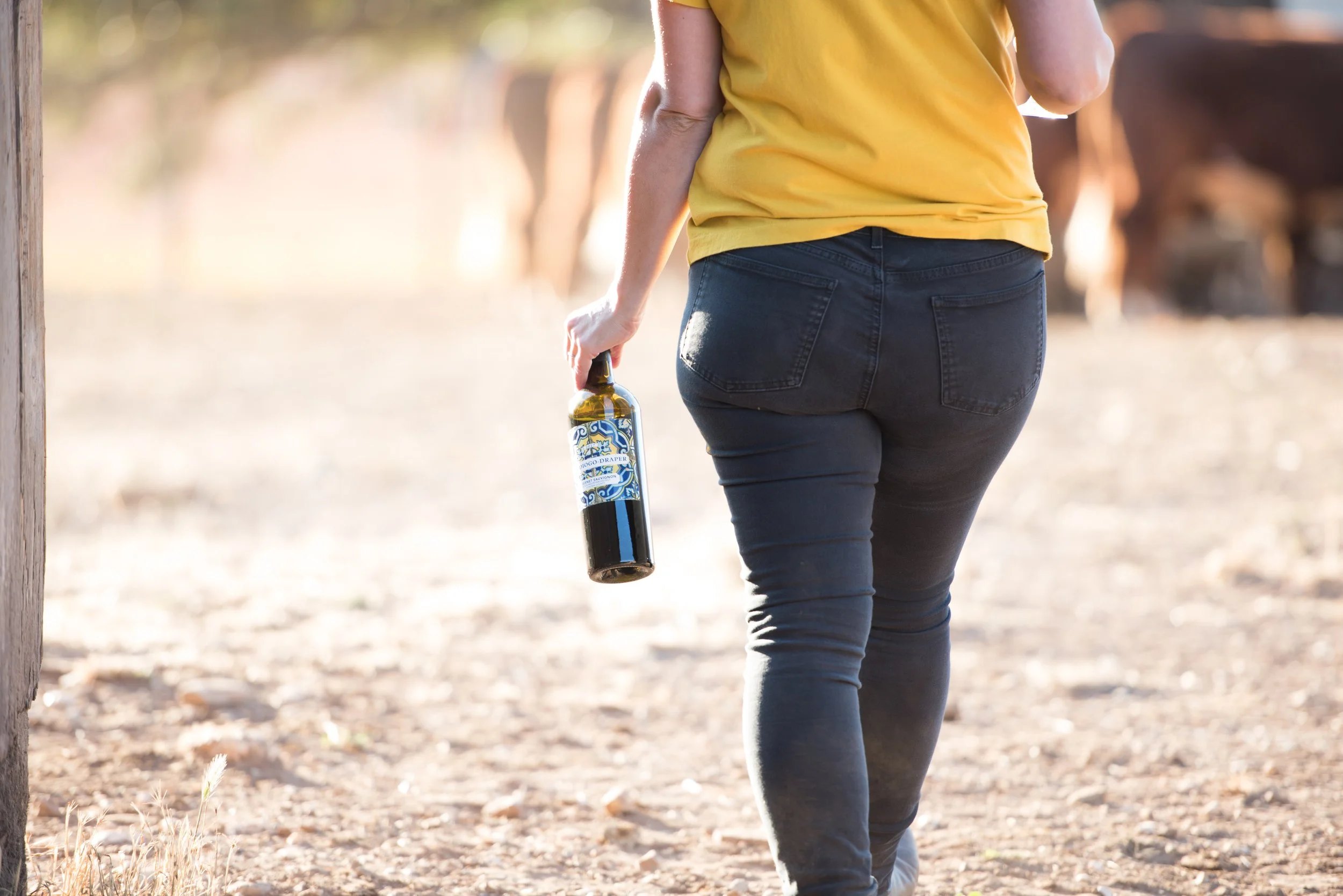 winemaker carrying bottle of wine