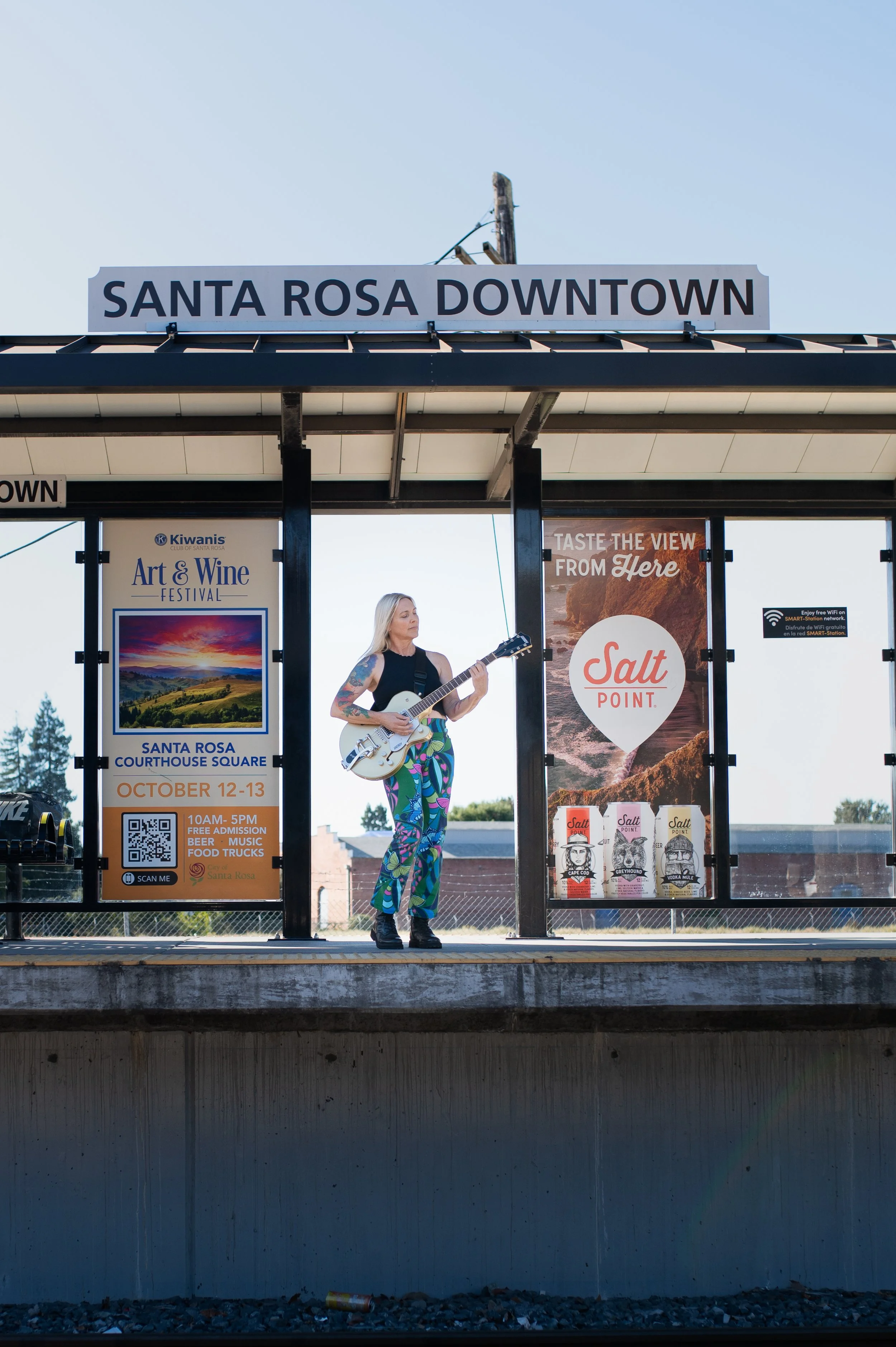 woman playing guitar at train station 