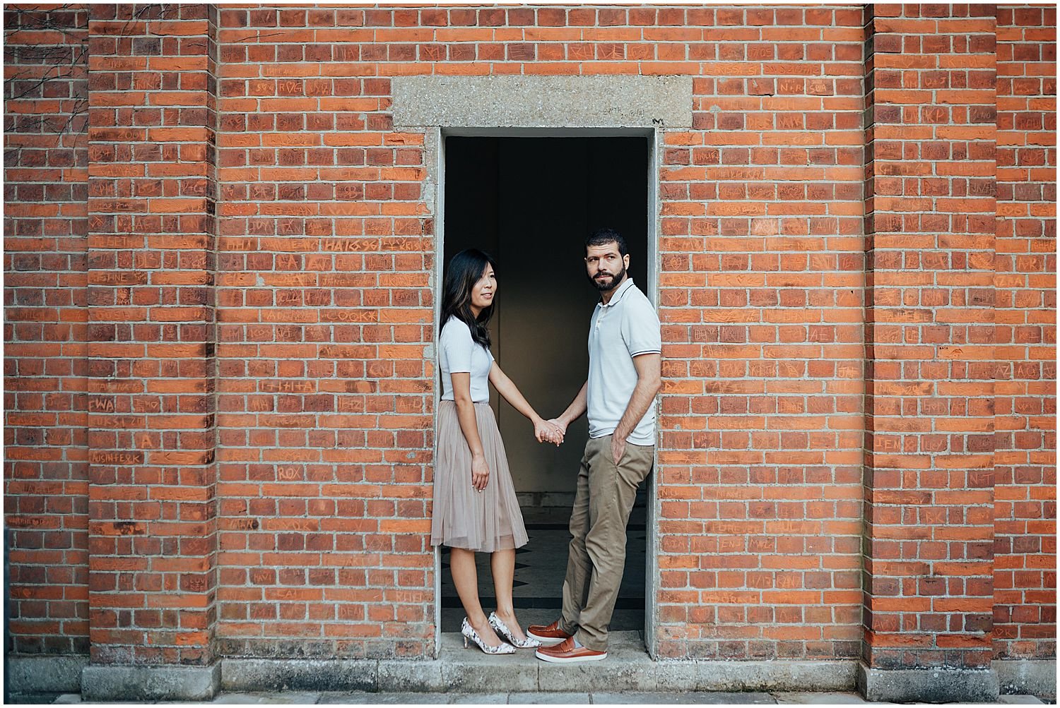 London couple standing in old brick doorway