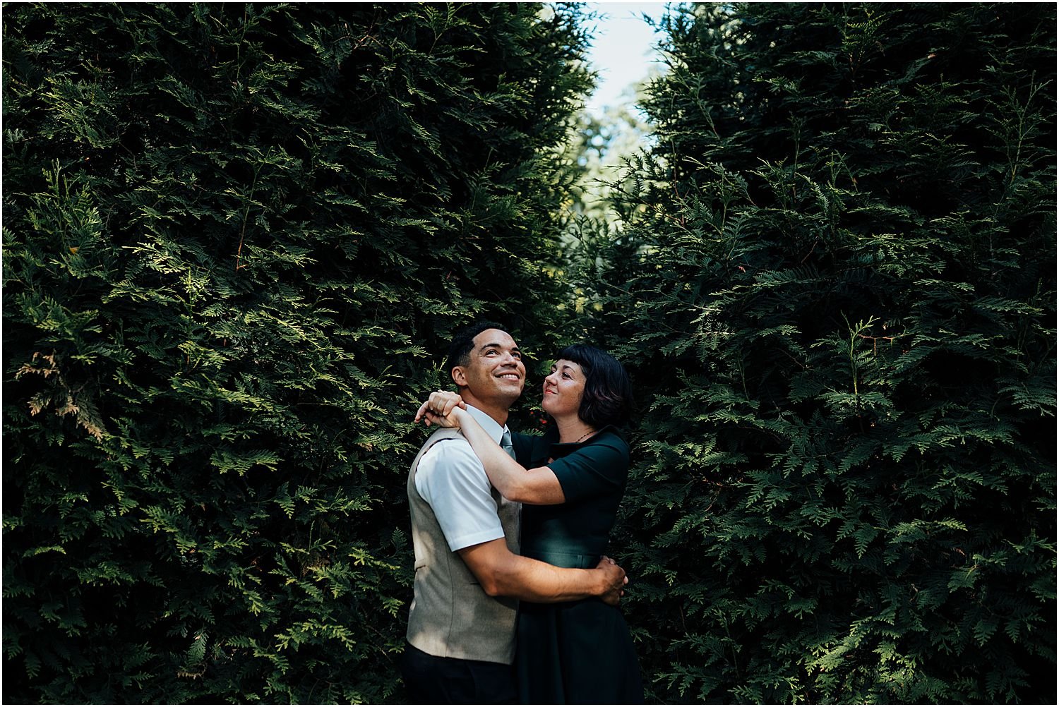 Couple hugging in front of trees 