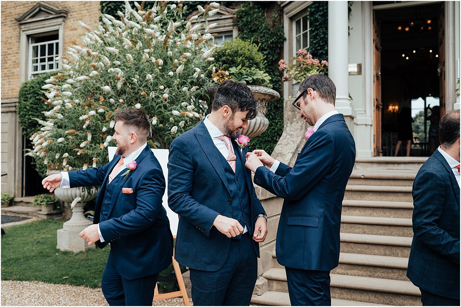 Groom putting on button holes before ceremony 