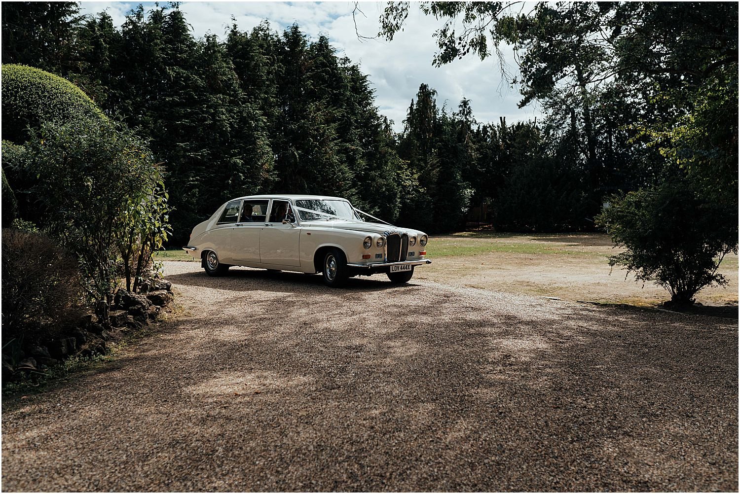 Vintage wedding car arriving at Hampton Court House