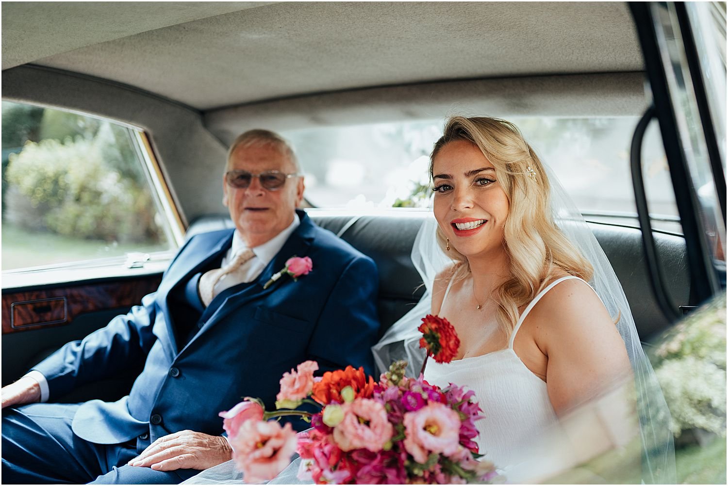 Bride and father sitting in wedding car