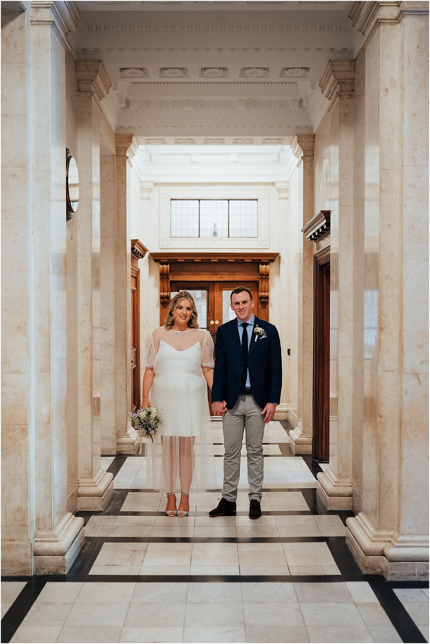 Bride and groom standing in hallway