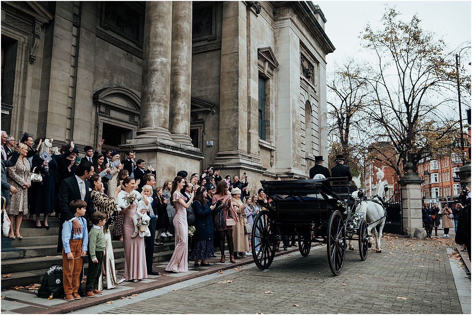 Bride and groom leaving oratory in horse and carriage