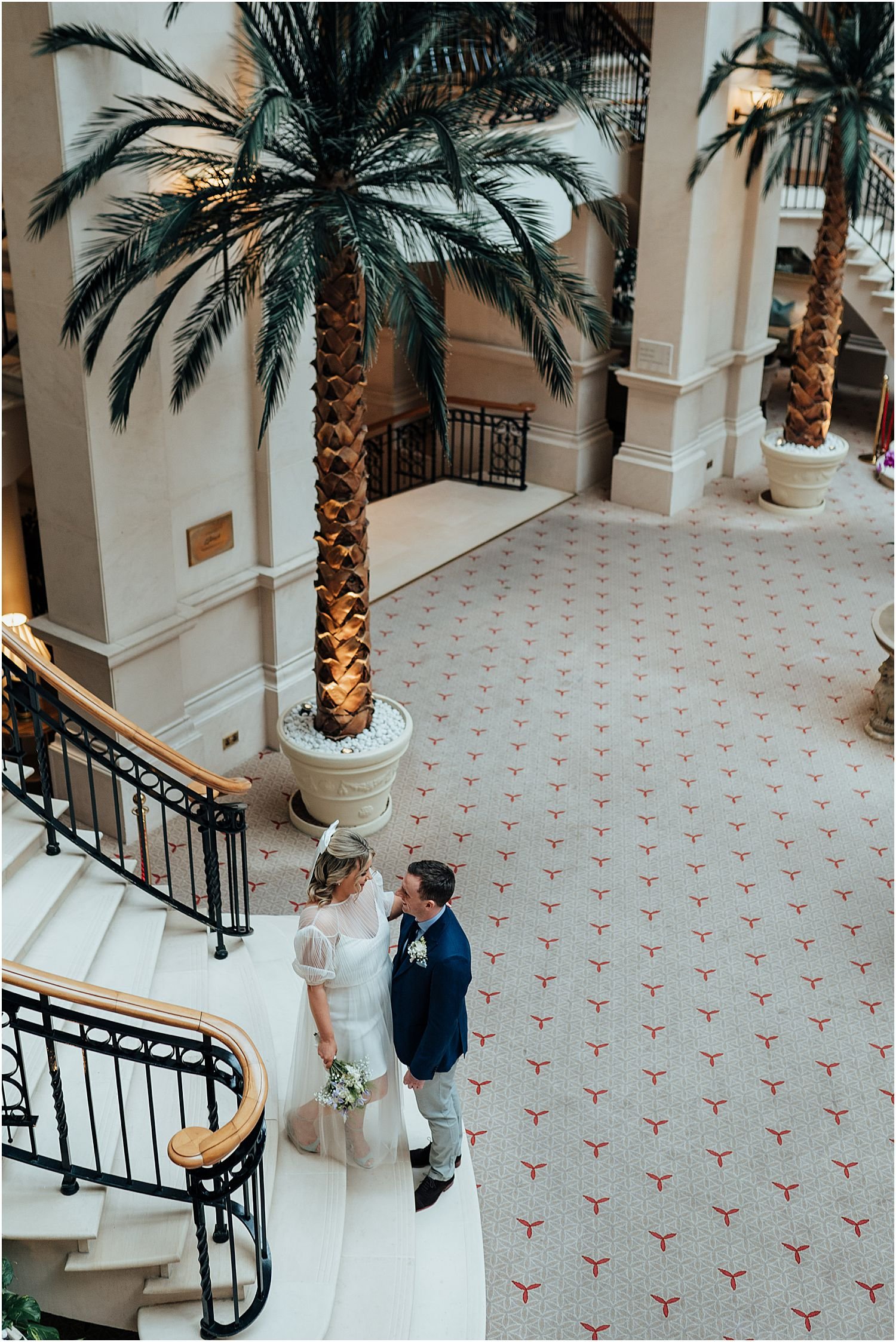 Bride and groom on stairs in Landmark Hotel London