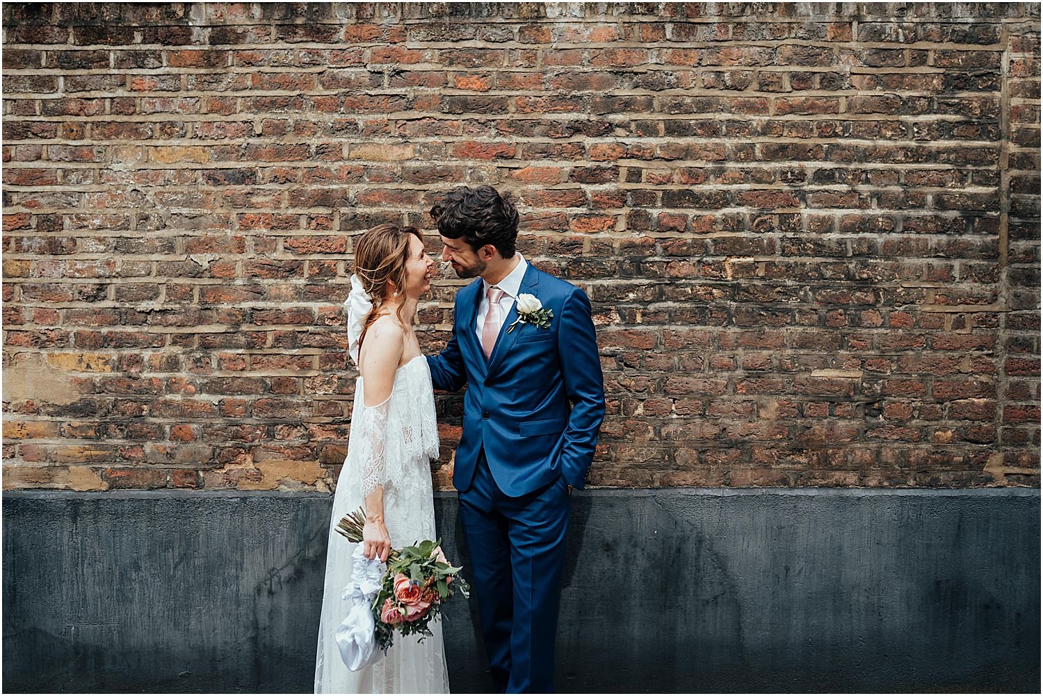 Bride and groom photo with brick wall