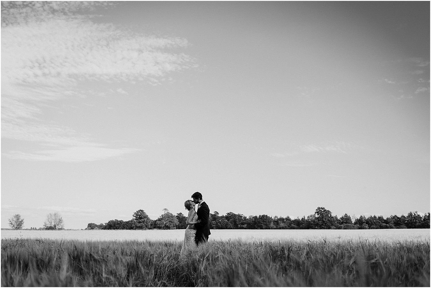 Bride and groom in field at golden hour