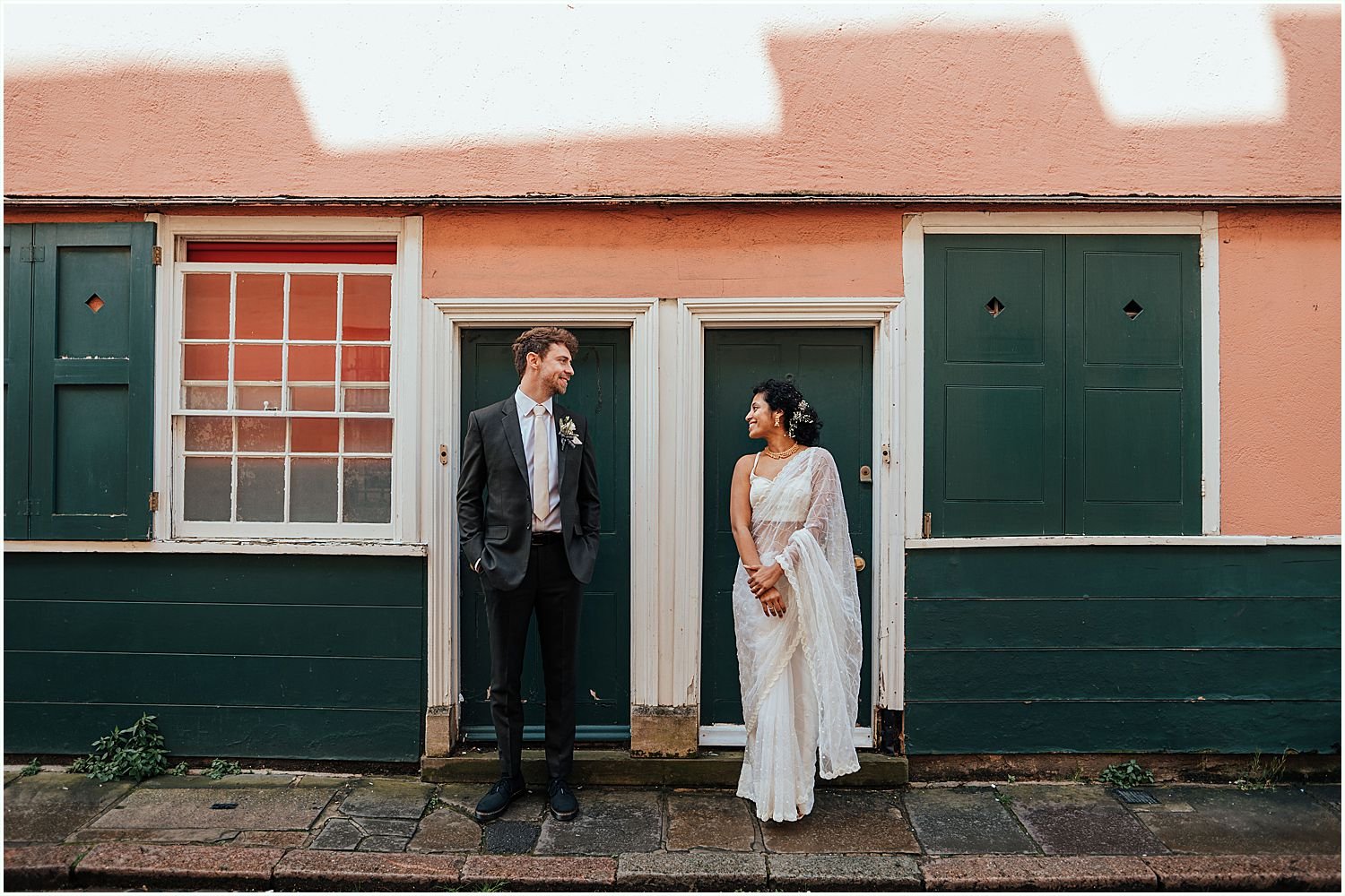 Bride and groom outside colourful house after their Oxford Town Hall wedding
