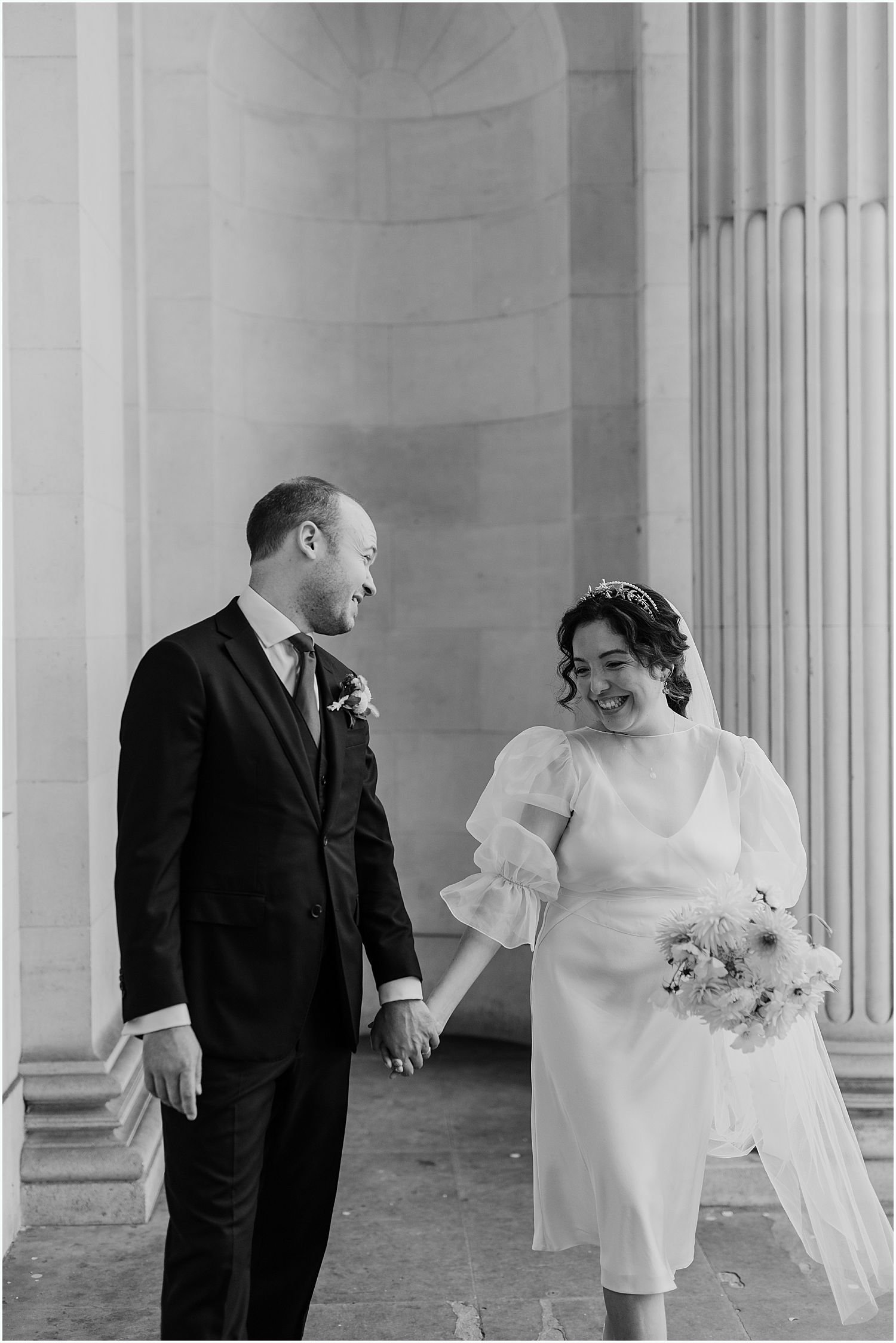 Candid black and white photo of bride and groom at the Old Marylebone Town Hall