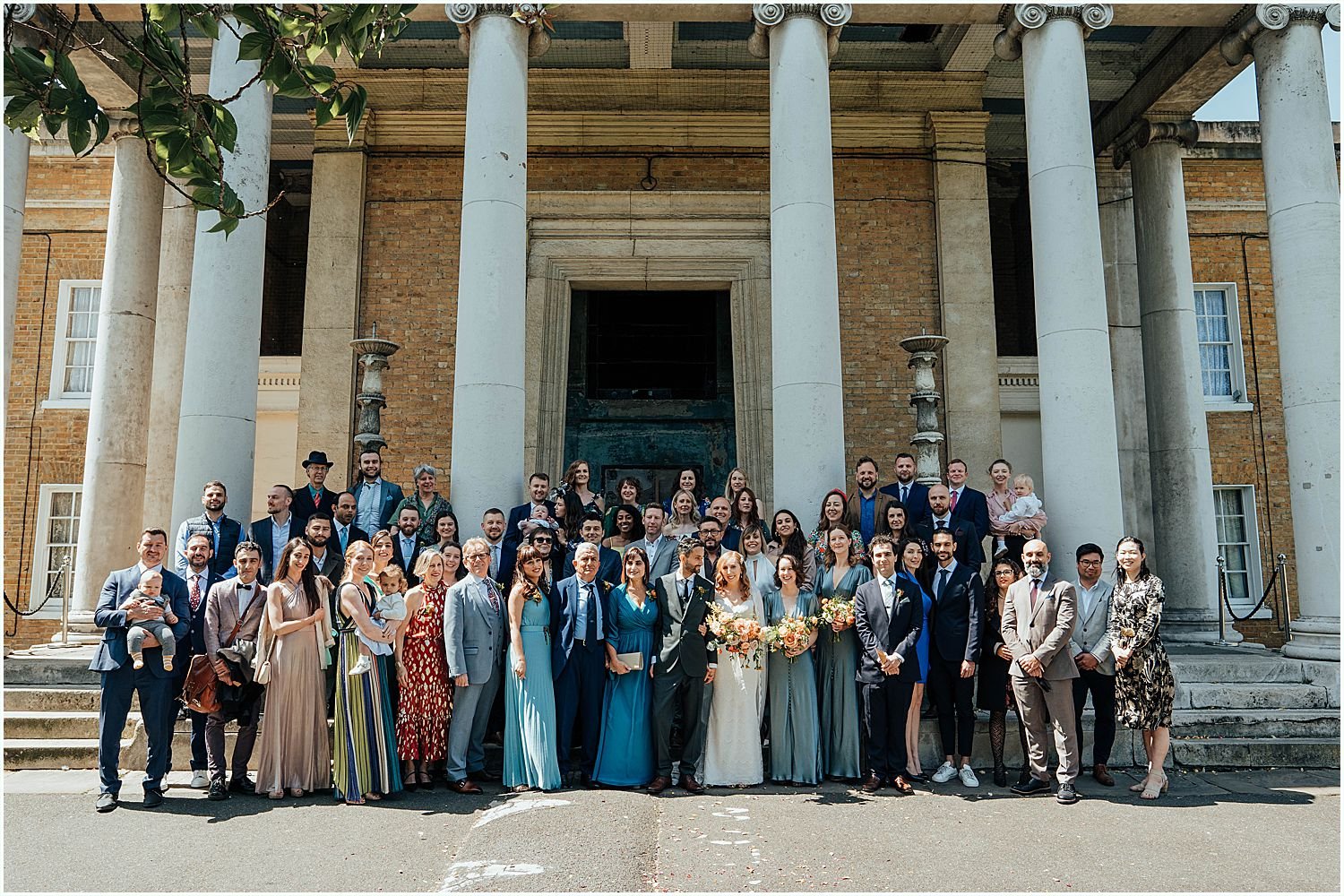 Group photo of wedding guests outside Asylum Chapel in Southeast London
