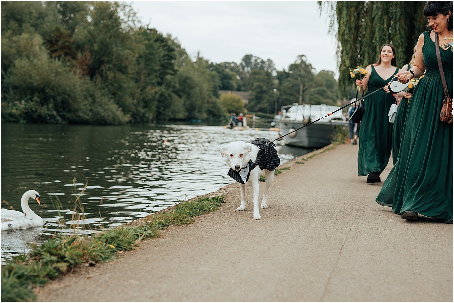 Bridesmaids arriving with dog along the river