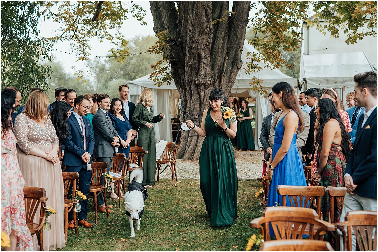 Bridesmaid with dog walking down the aisle