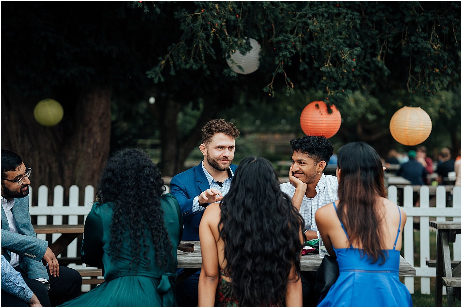 Wedding guests enjoying drinks on lawn at Isis River Farmhouse