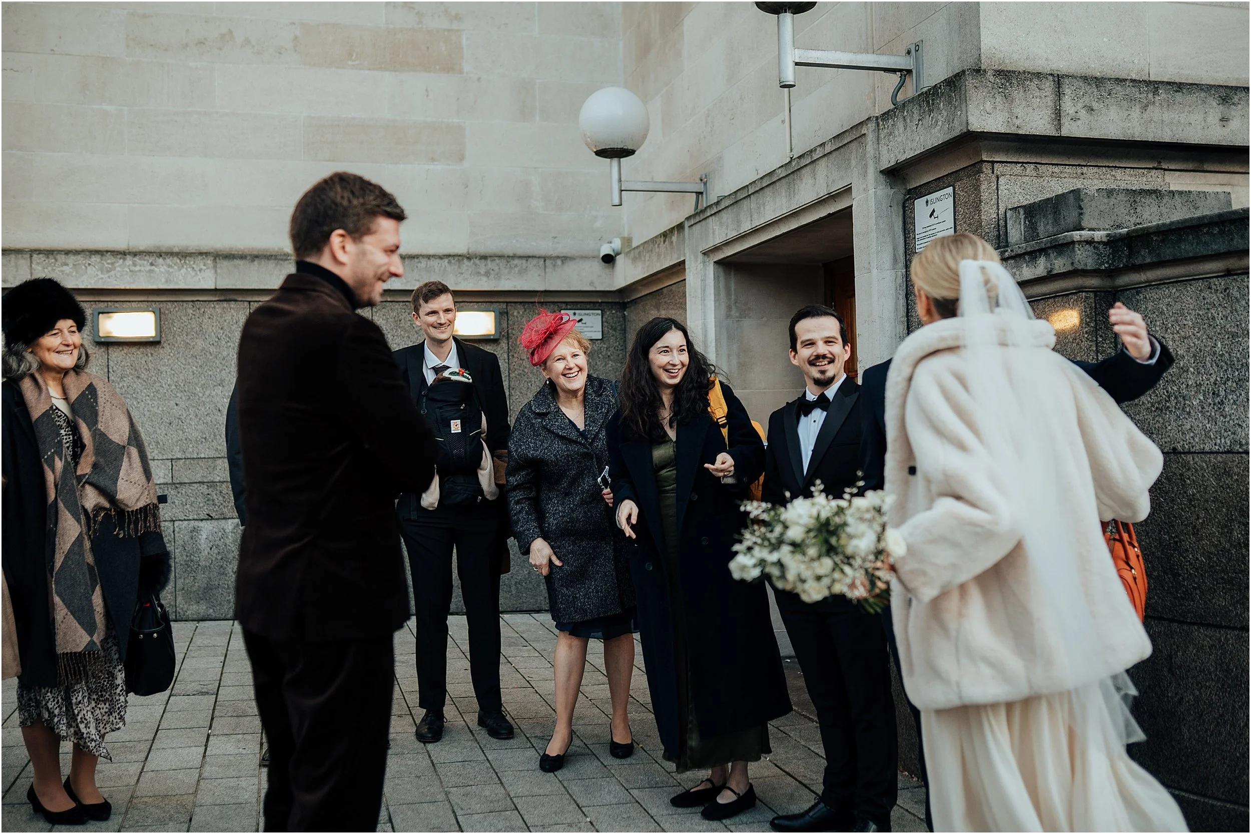 Wedding guests greeting couple as they arrive at Islington Town Hall