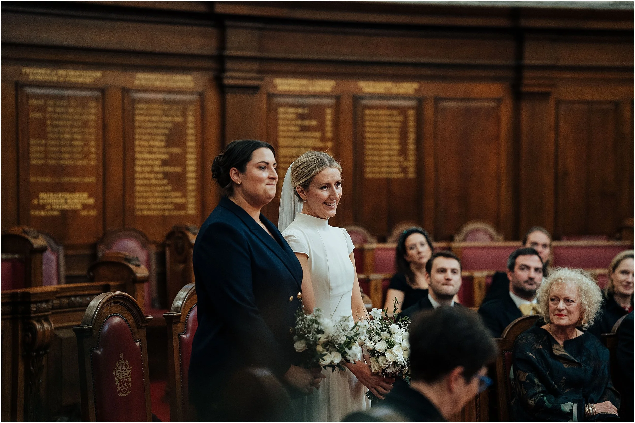 Two brides listening to reading during their wedding ceremony