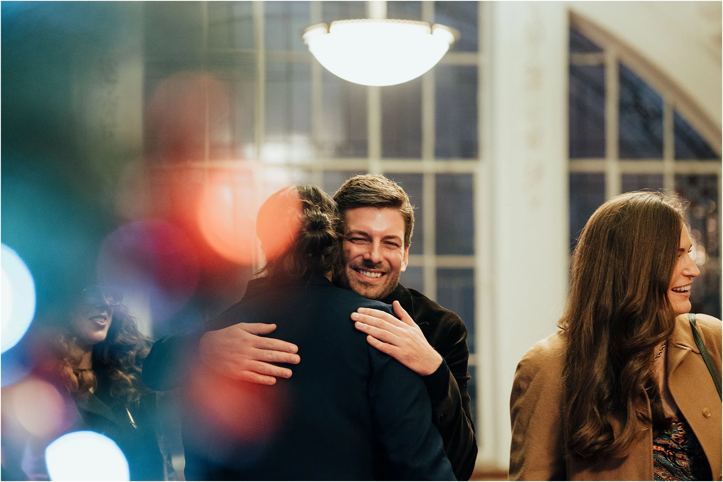Guests hugging brides after ceremony