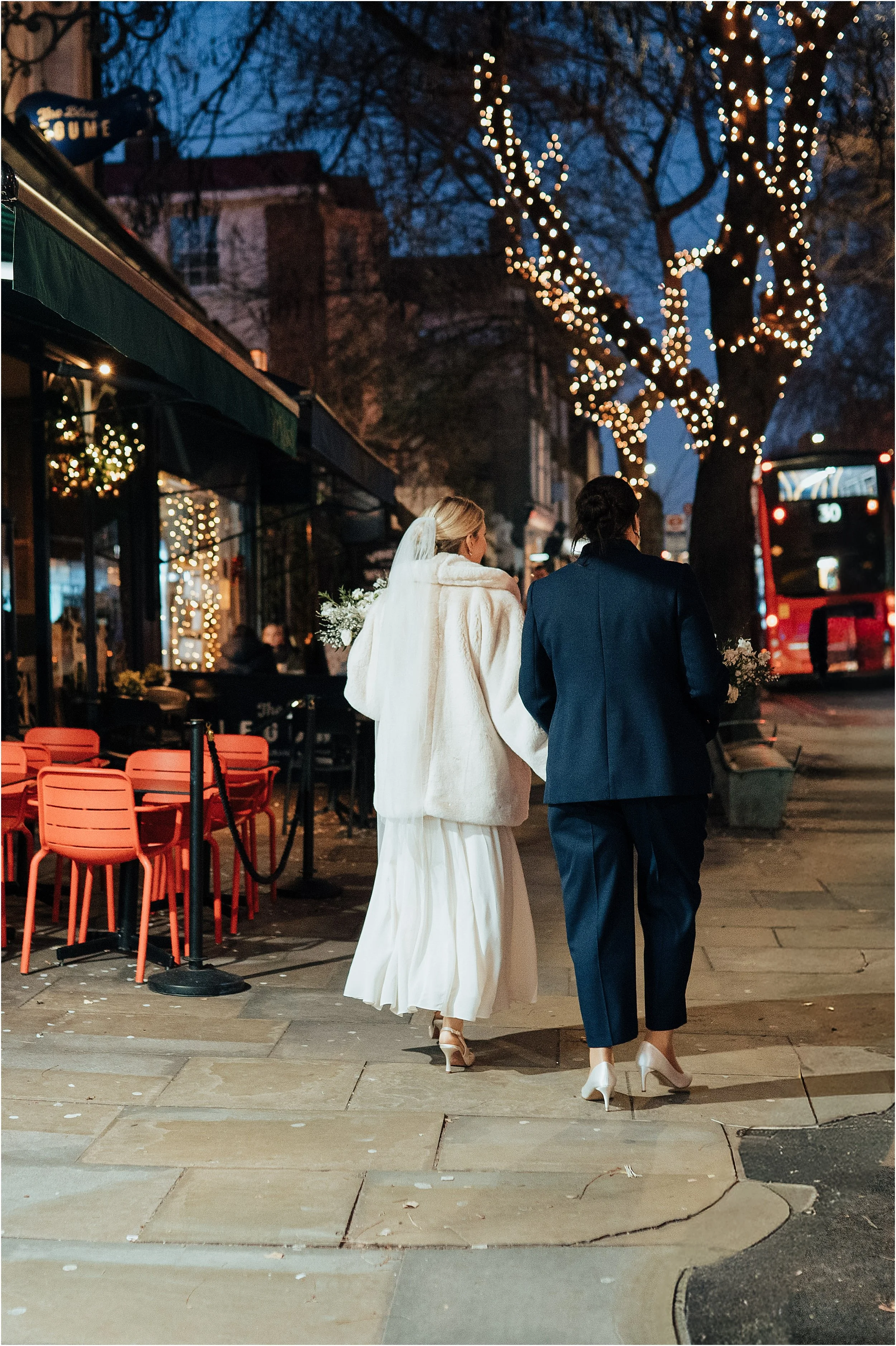 Newlyweds walking on Christmassy Upper Street, Islington 