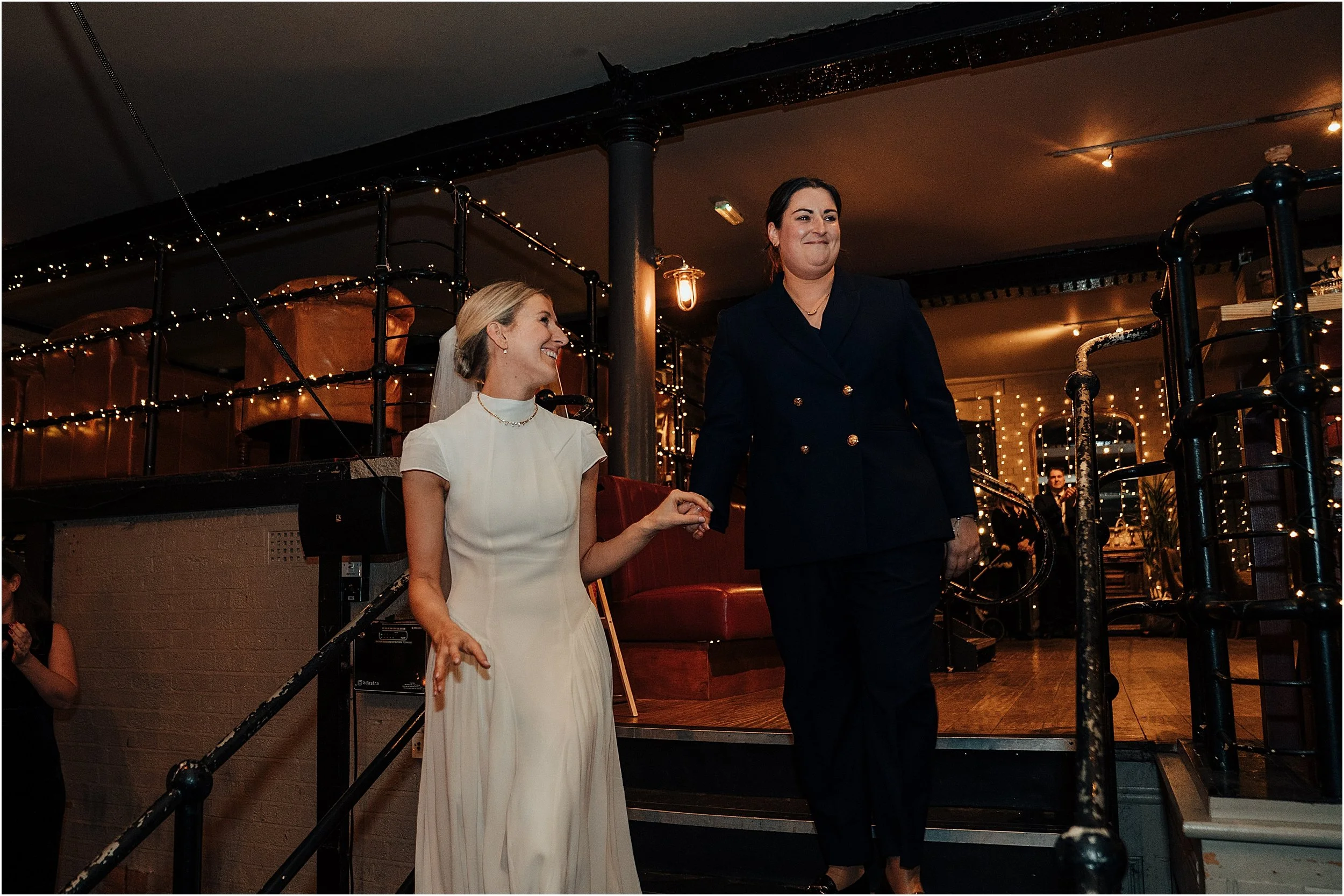 Lesbian couple entering reception room on their wedding day at the Depot