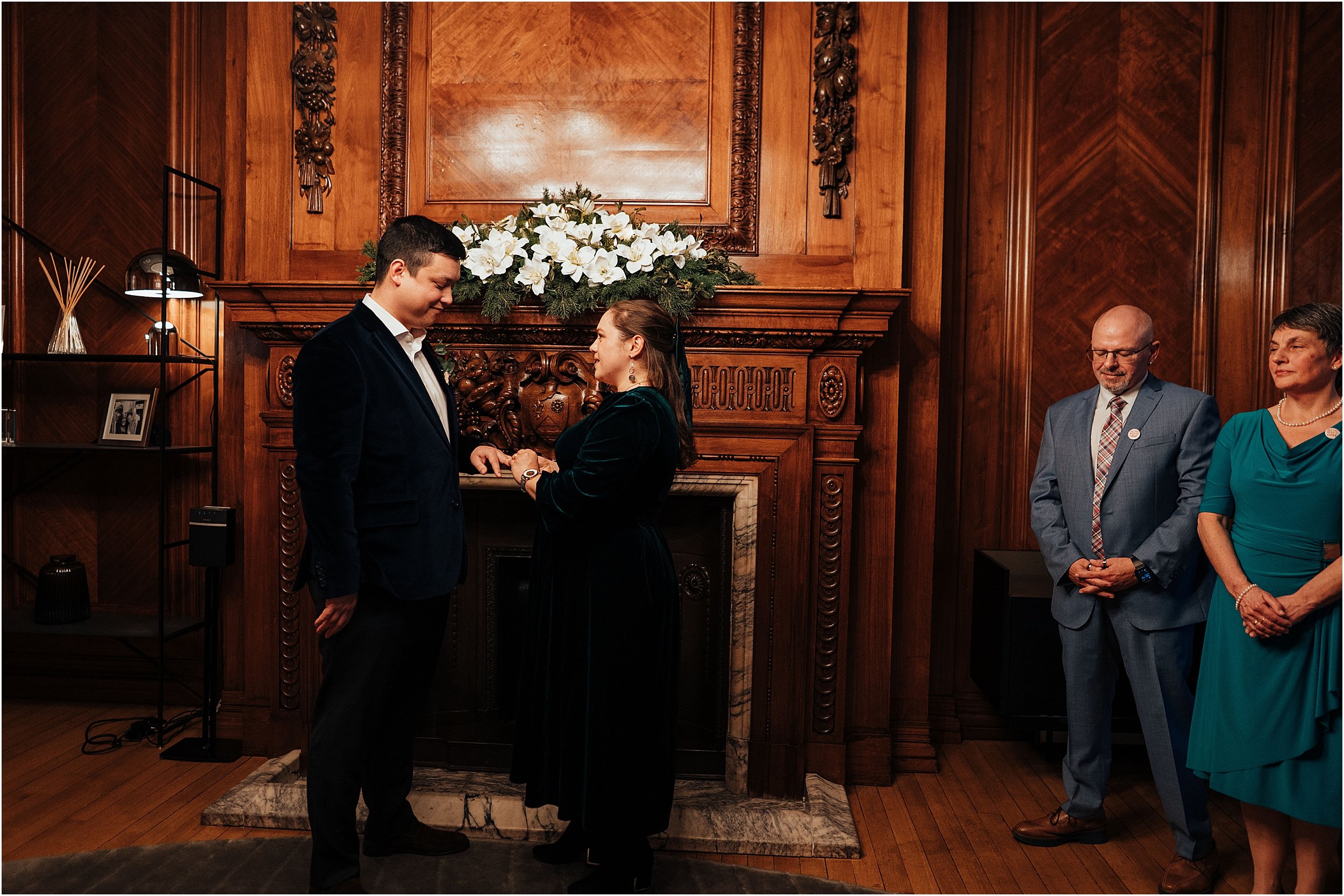 Bride and groom exchanging rings during winter wedding ceremony at Marylebone Town Hall