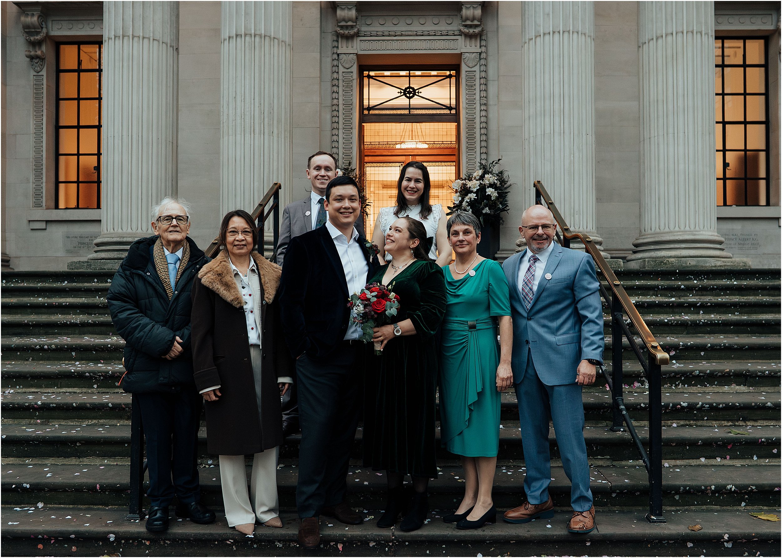 Group wedding photo with family on steps outside town hall