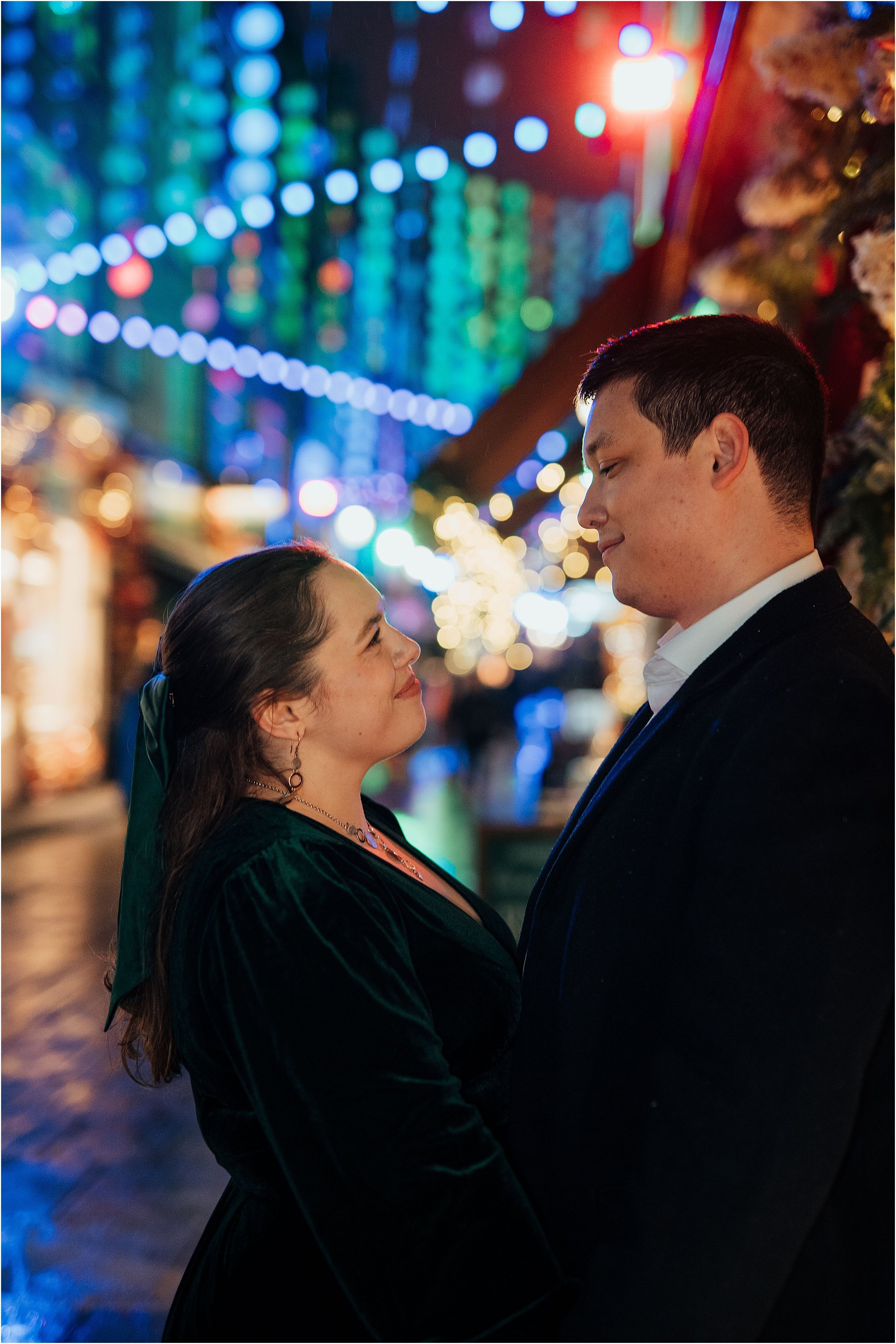 Close up portrait of bride and groom with colourful Christmas lights in London
