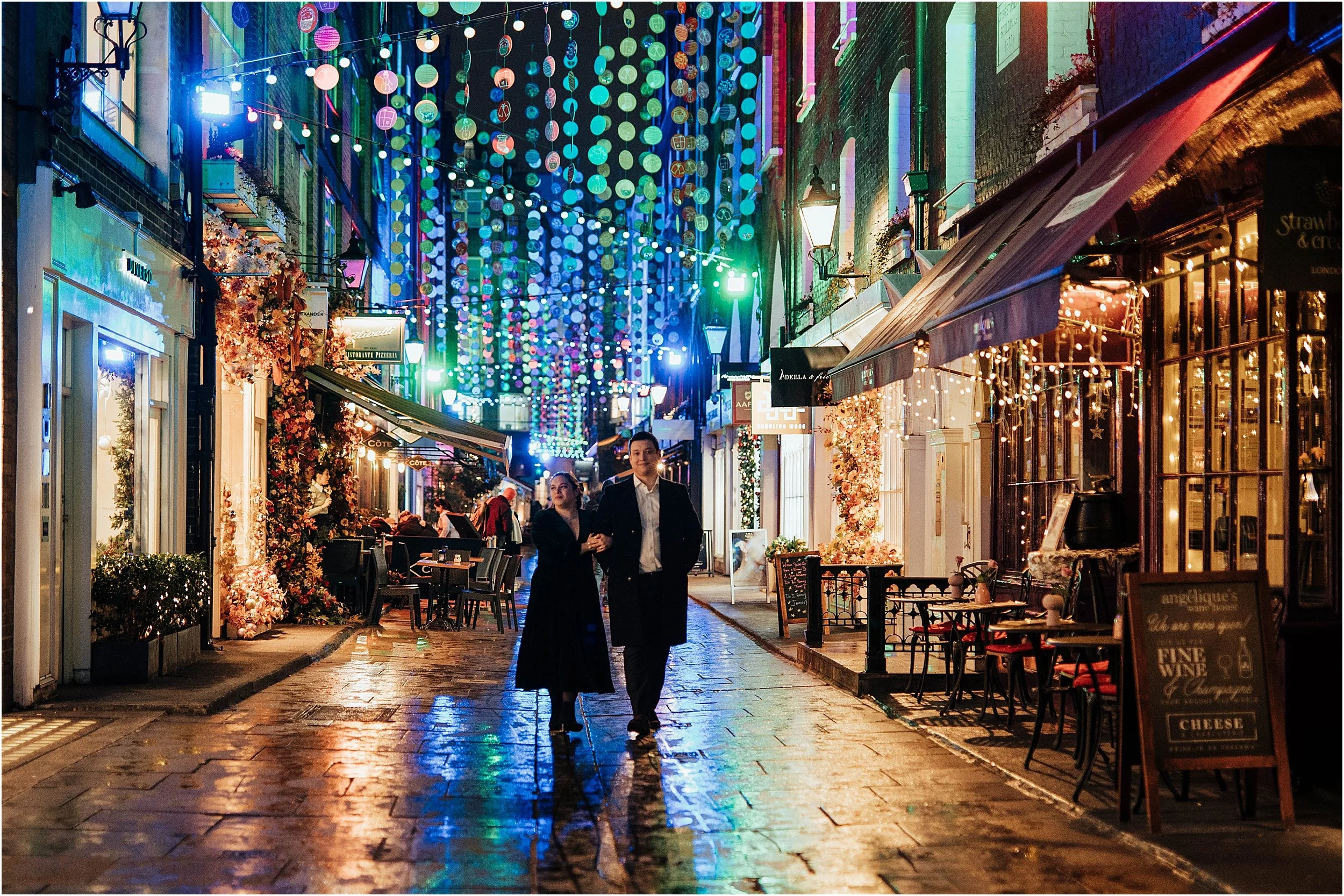 Newlywed couple walking down London street with Christmas lights