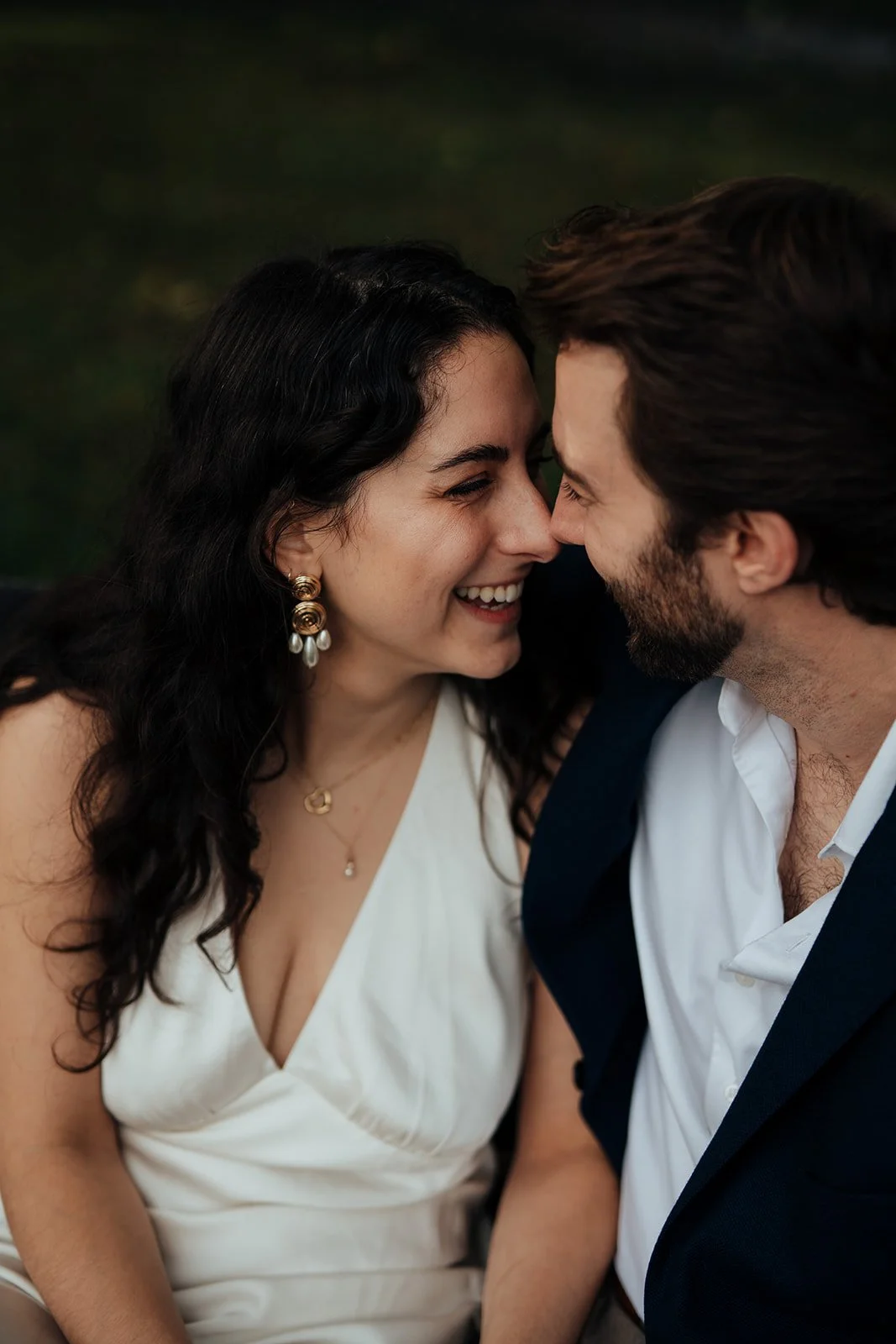 Newly engaged couple laughing together on park bench