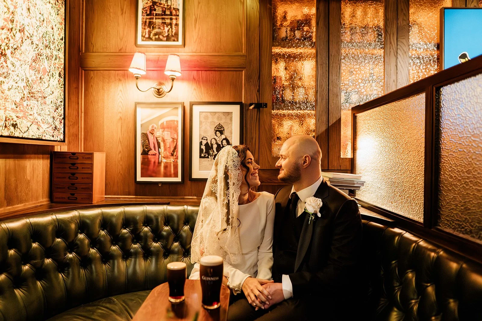Bride and Groom sharing a guinness on their wedding day in pub
