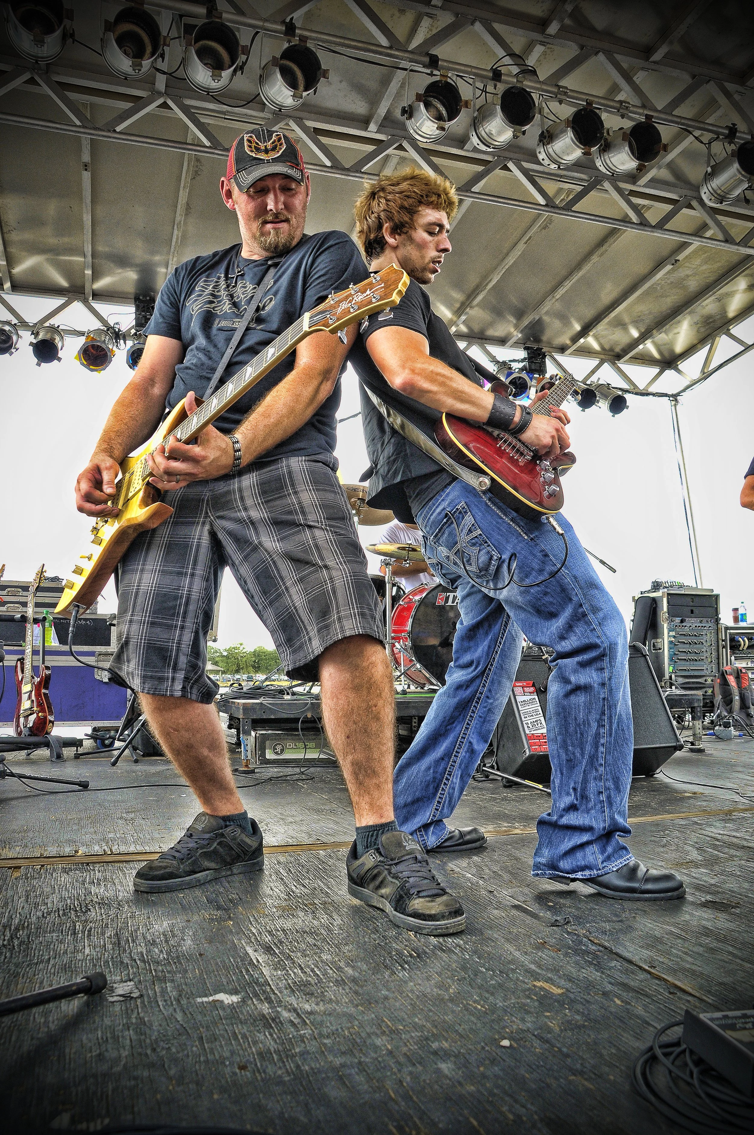 Sean Guerrero performing guitar onstage alongside another guitarist