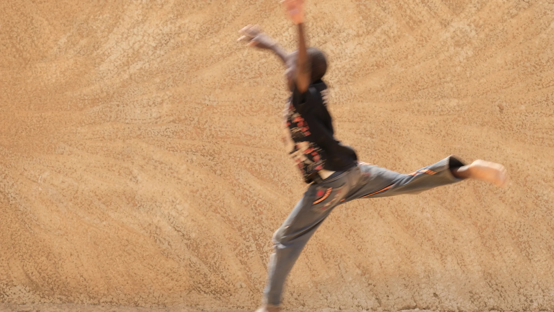 Moussa, age 10, takes flight in front of the wall outside of the informal site in Mopti where his family fled to after a deadly raid in his village by an armed group. He just wants to return home. But in the midst of uncertainty and displacement he …