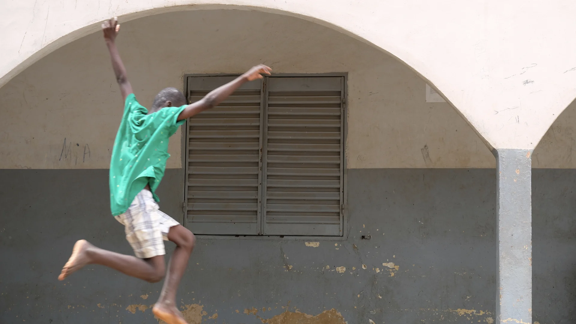 Ten year old Balla jumps into the air at a refuge for children who have been separated from their parents. Some of the boys at the center have been there for months and have no idea when they will go home. The boys have created a supportive communit…